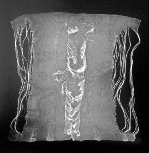 A transparent square fabric with frayed edges, displaying a pattern of wavy lines and shapes in white against a black background.