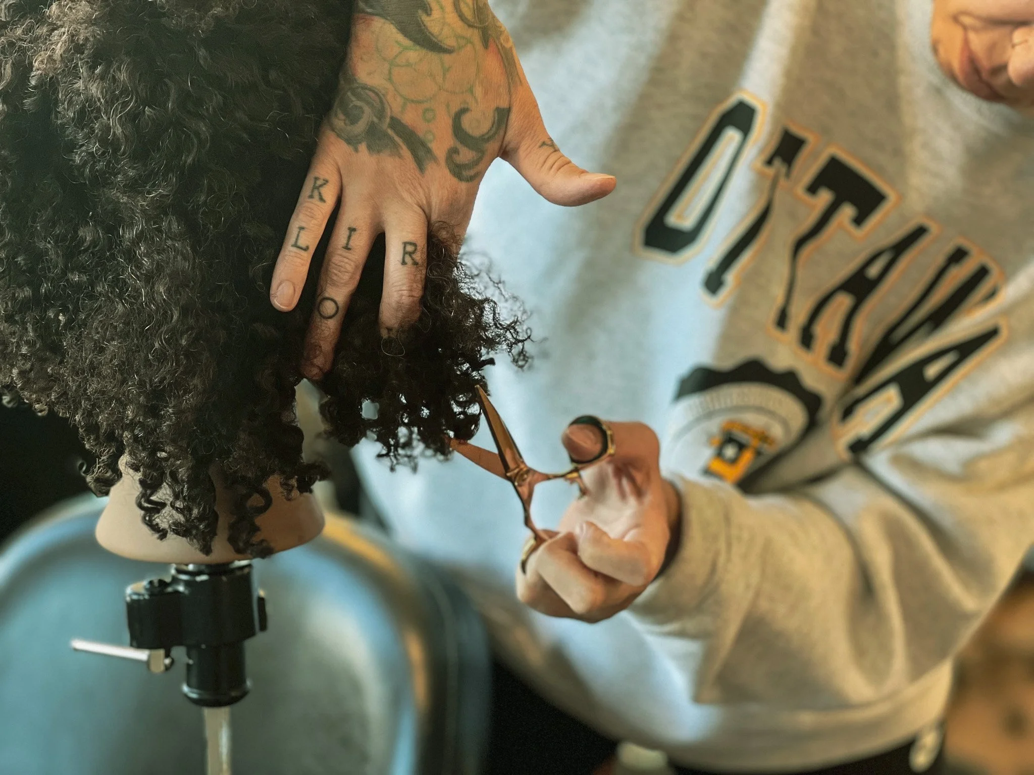 An artist cuts curly hair.
