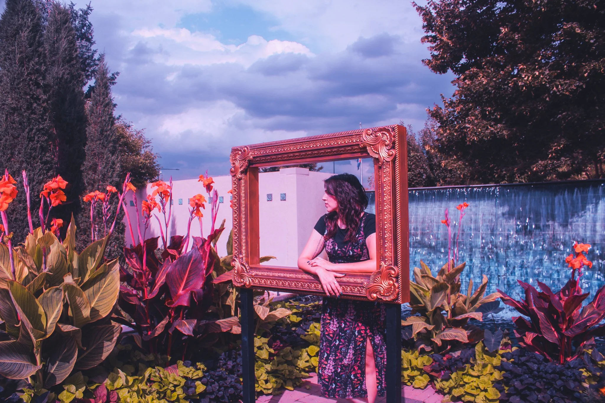 Emma Stewart poses behind an empty picture frame inside the Denver Botanic Gardens.