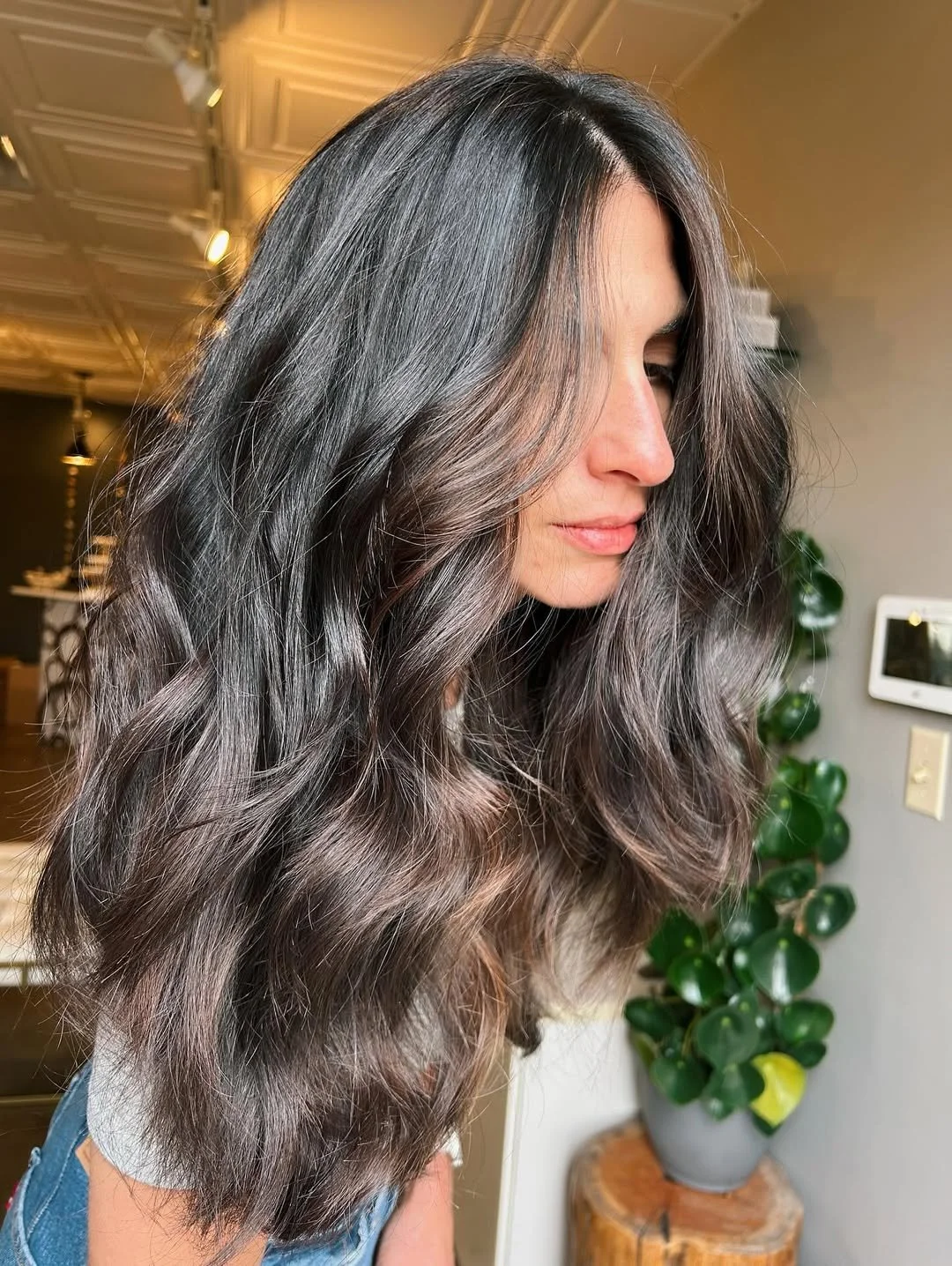 Glossy mocha brunette with soft ribbons of dimension, face-framing light and long layers for that easy movement. Finished with big brush waves so it shines in Denver light.

Hair by @megan.b.beauty at Starling Salon.