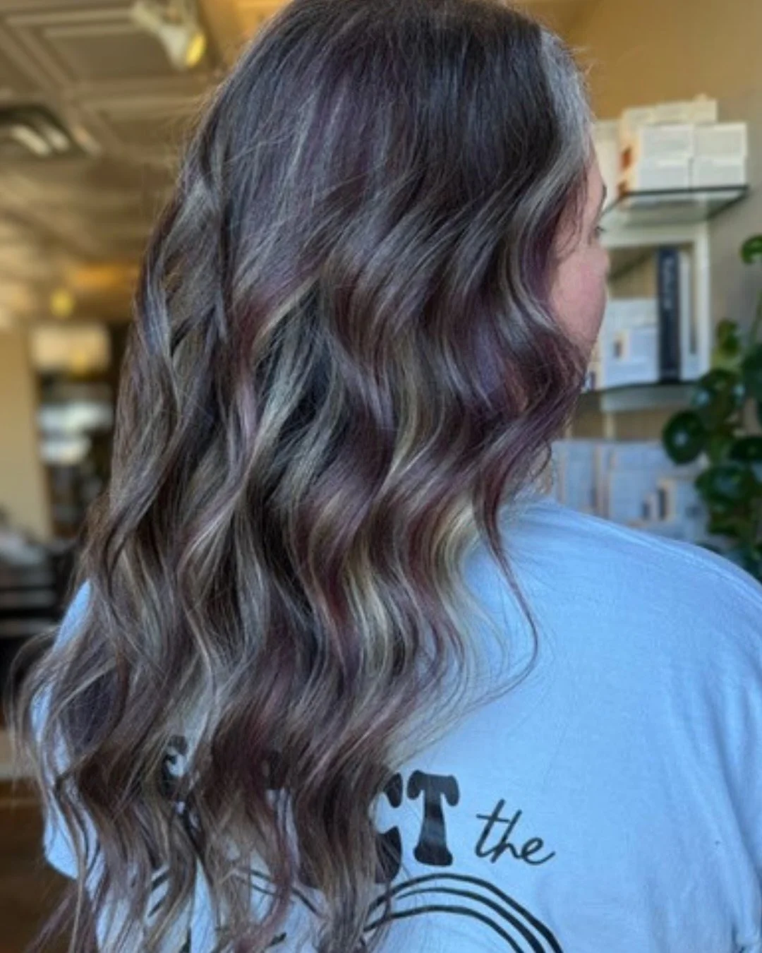 This is dimension where you can actually see the dimension.

Hallie placed bold blonde ribbons inside a plum-tinted brunette base. The contrast width is the point. Softer streaks would disappear against this depth and leave you with brunette that loo