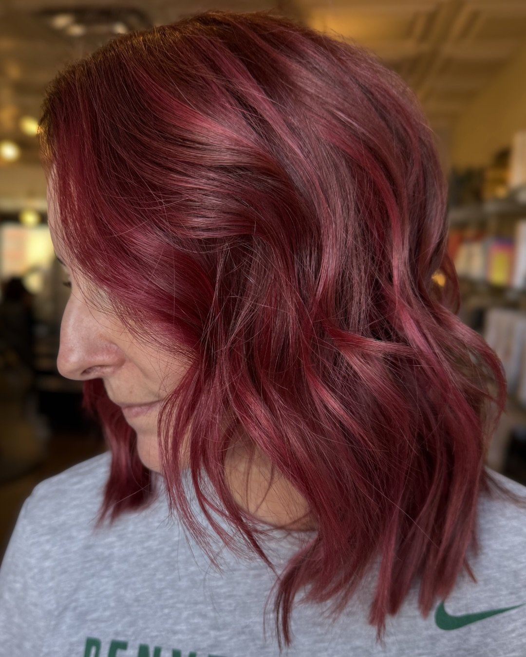 This raspberry will still read raspberry six weeks from now.

Hallie built it with a deeper base than most colorists would, which is why the color reads saturated from root to ends. The brighter pieces around the face are pulled in the same tone, jus