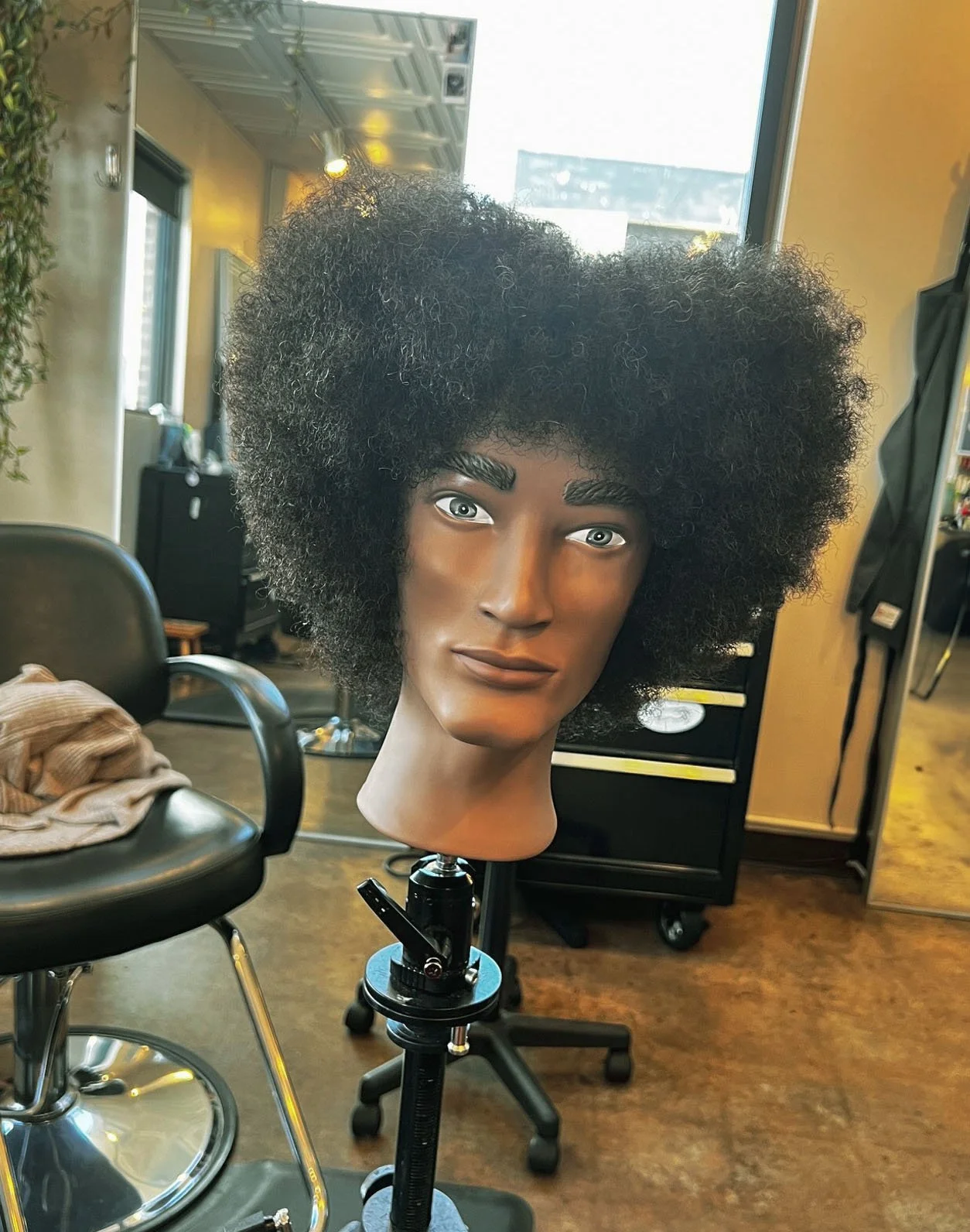 A heart-shaped curly hair style on a mannequin.