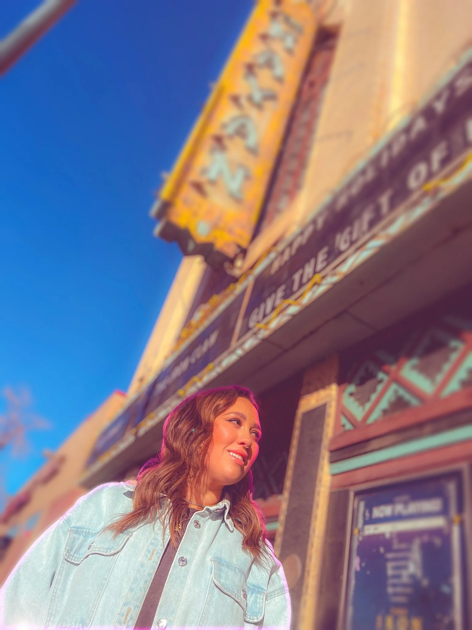 Megan Brockman standing outside the Mayan Theater in Denver, where a pink halo surrounds her.