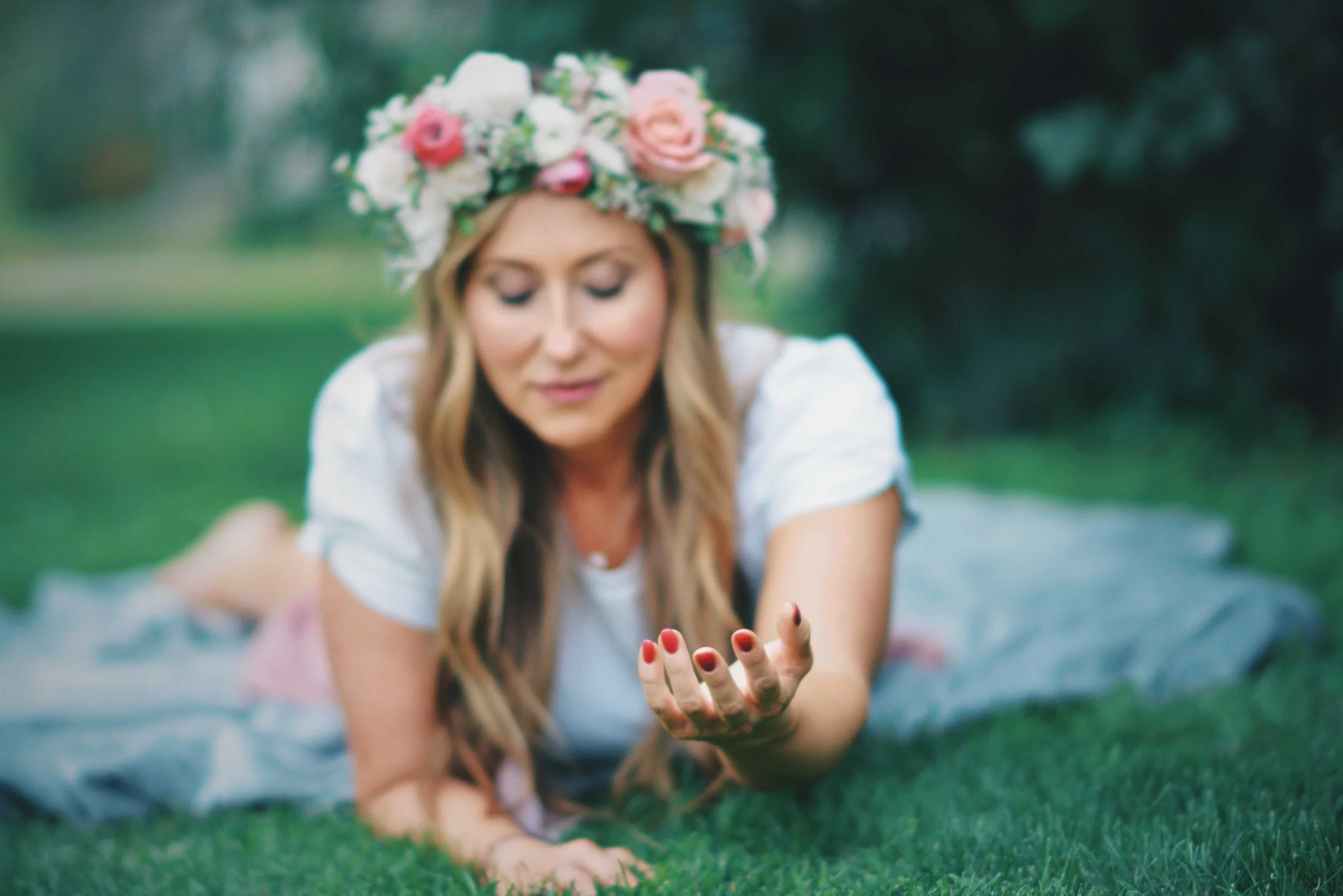 Sonia rests on the green grass with a come-hither look.