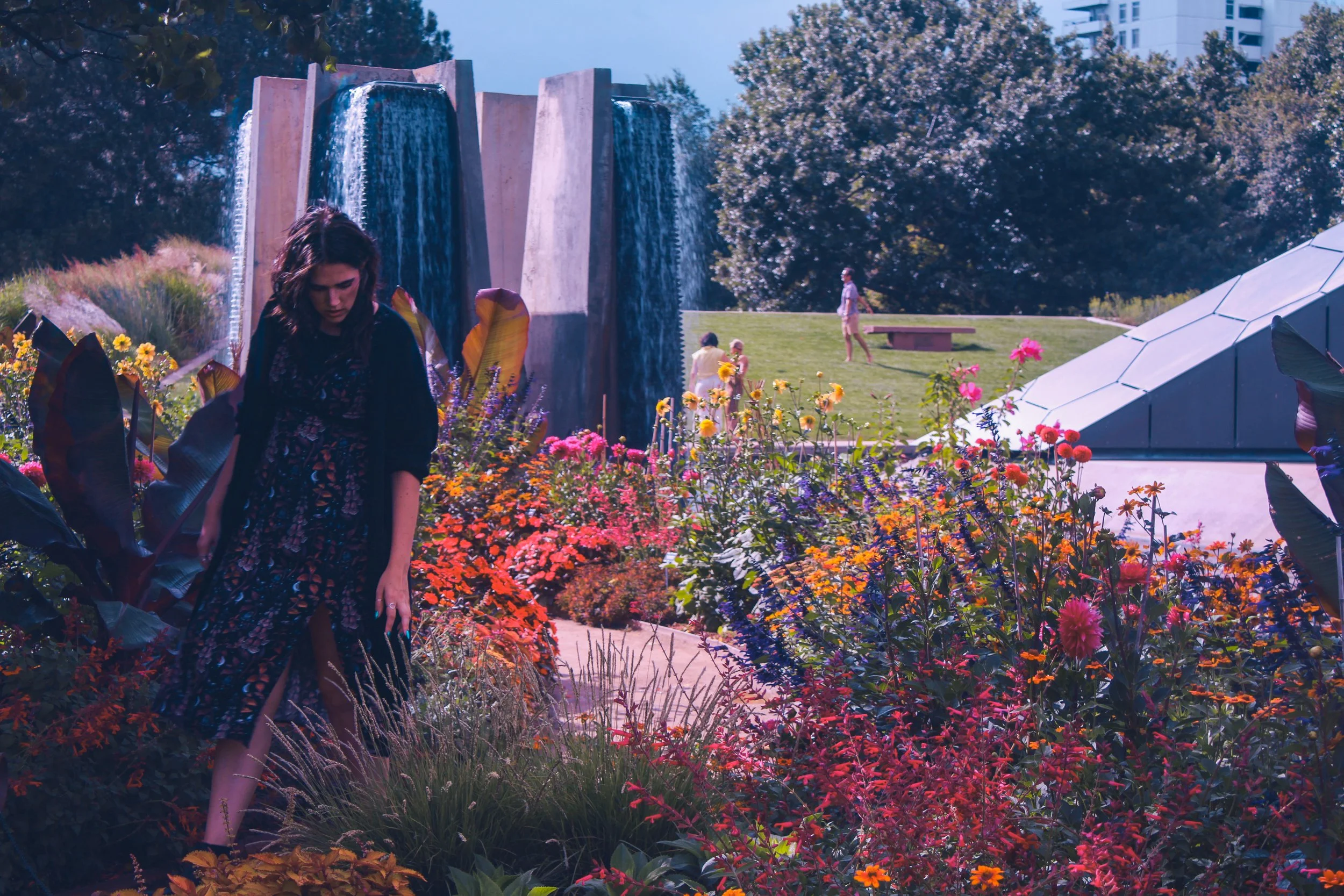 Emma walks through the Botanic Gardens with waterfalls behind her.