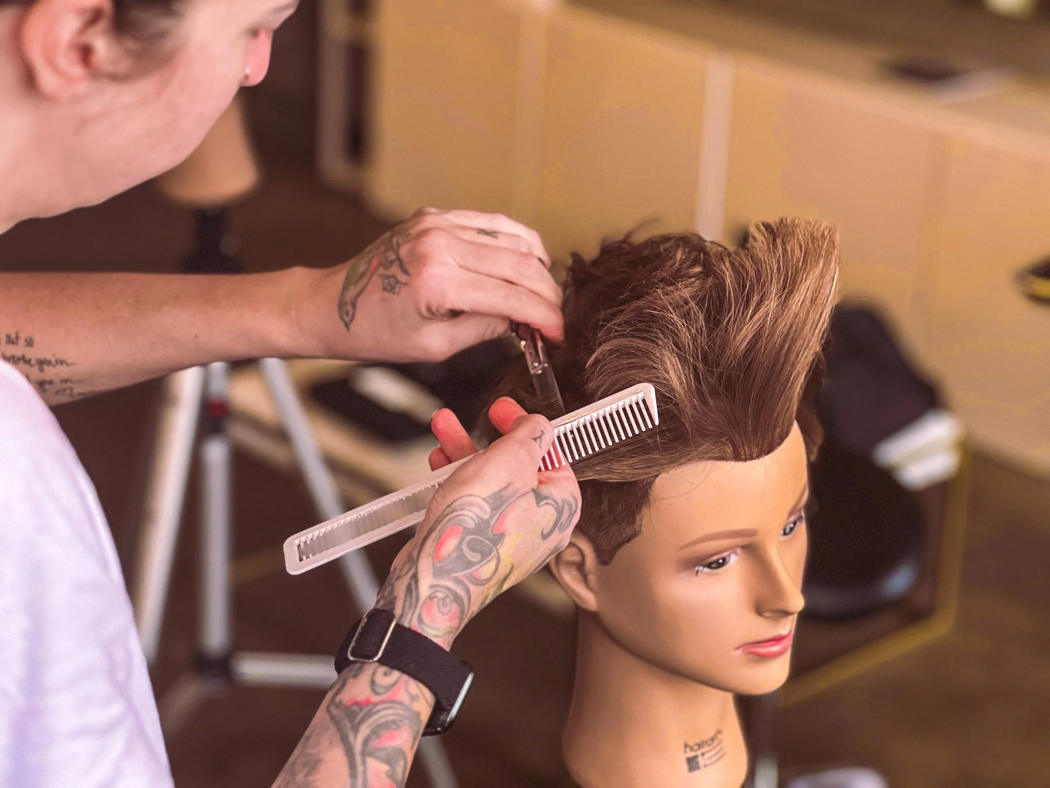Hallie Kastanek adds details to a short haircut on her mannequin.