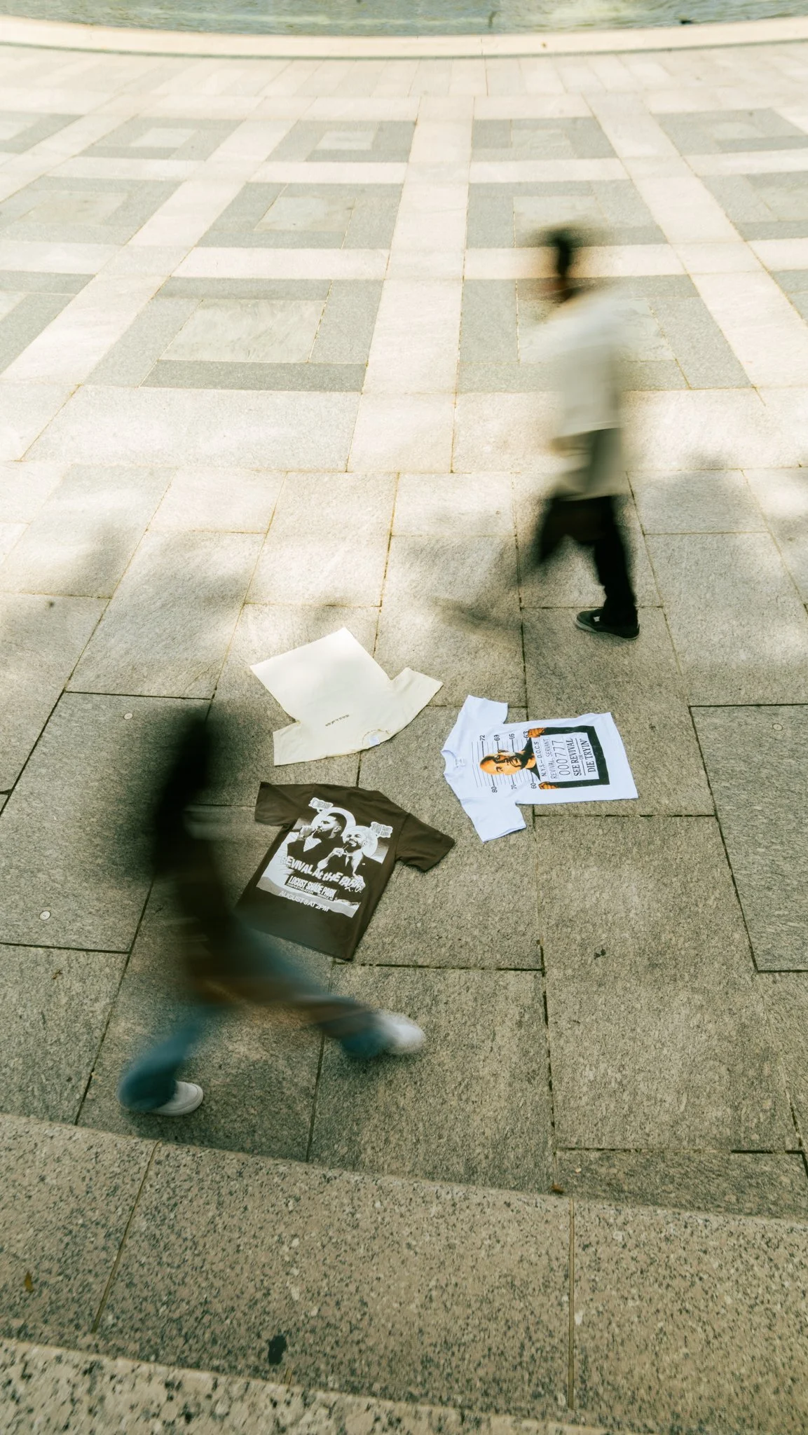 Blurred person walking past political flyers and posters on a pavement near water.