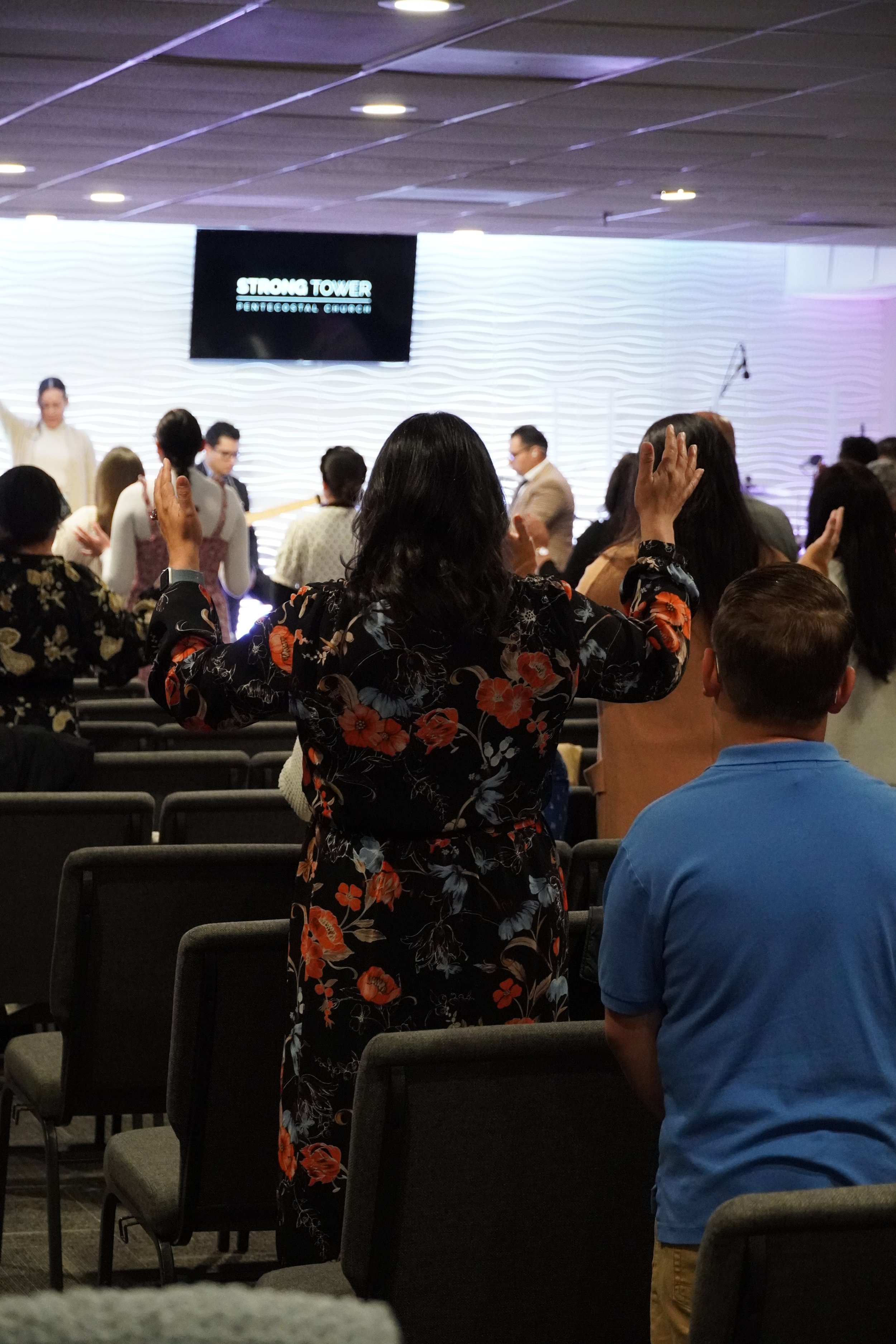 Spirit-filled worship at Strong Tower Pentecostal Church as people lift their hands in praise