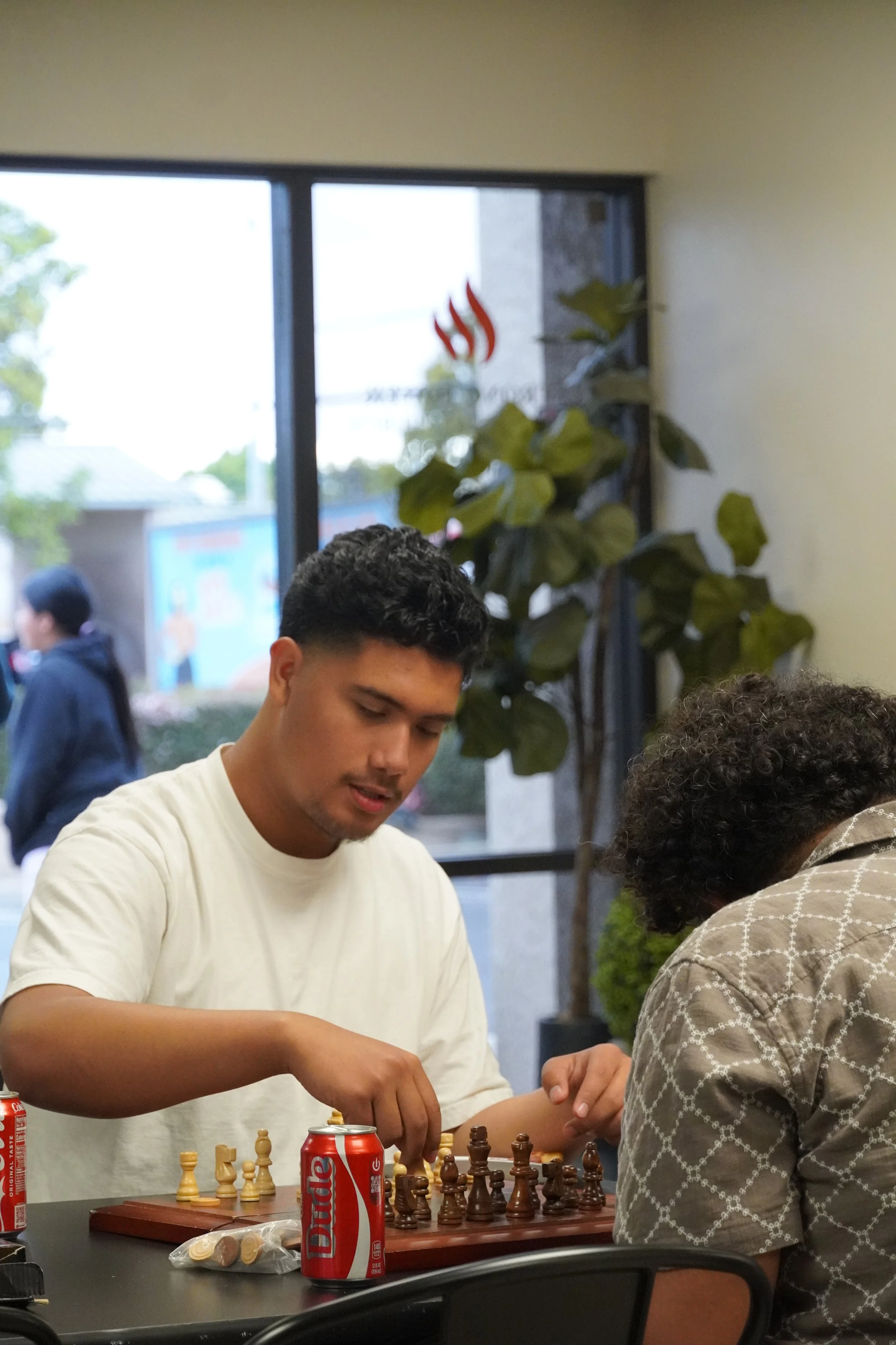 Youths playing chess as one of their activities while they continue to grow in fellowship and fait.