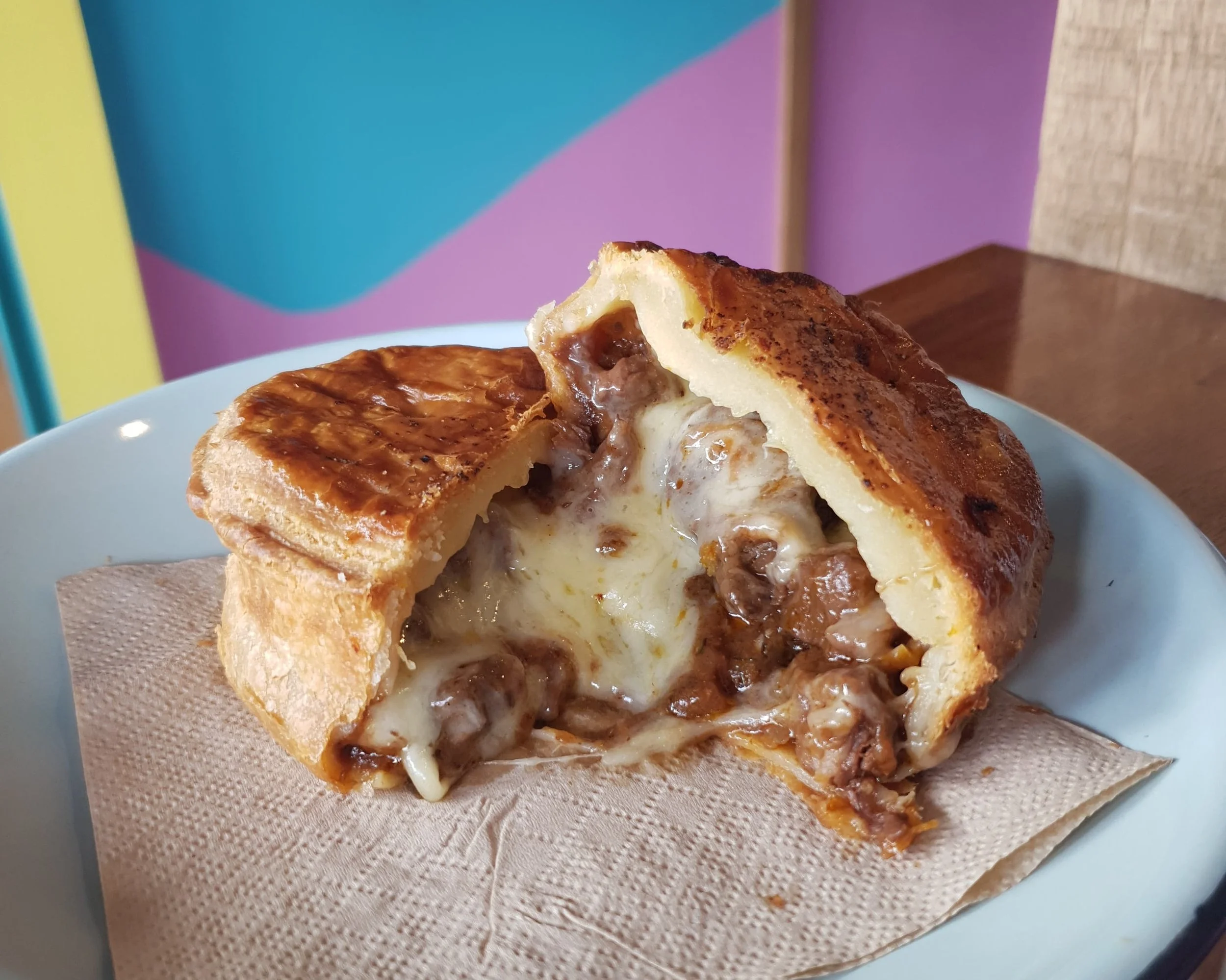Close-up of a steak and cheese pie with a flaky crust and gooey filling