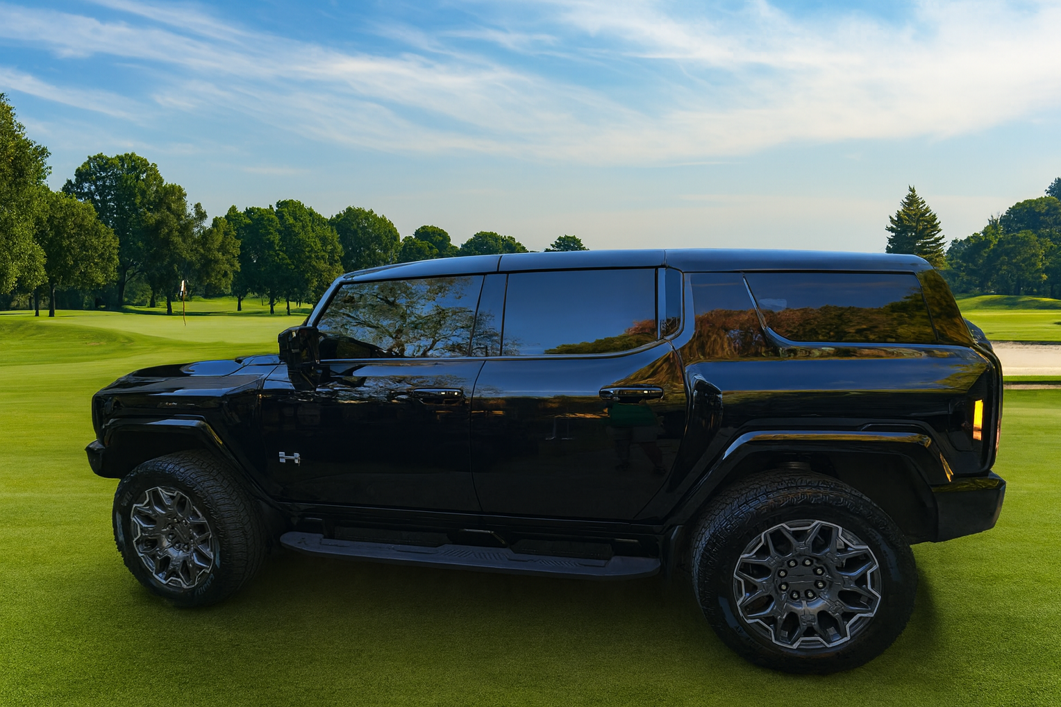 A black SUV parked on a golf course with green grass, trees, and a partly cloudy sky in the background.