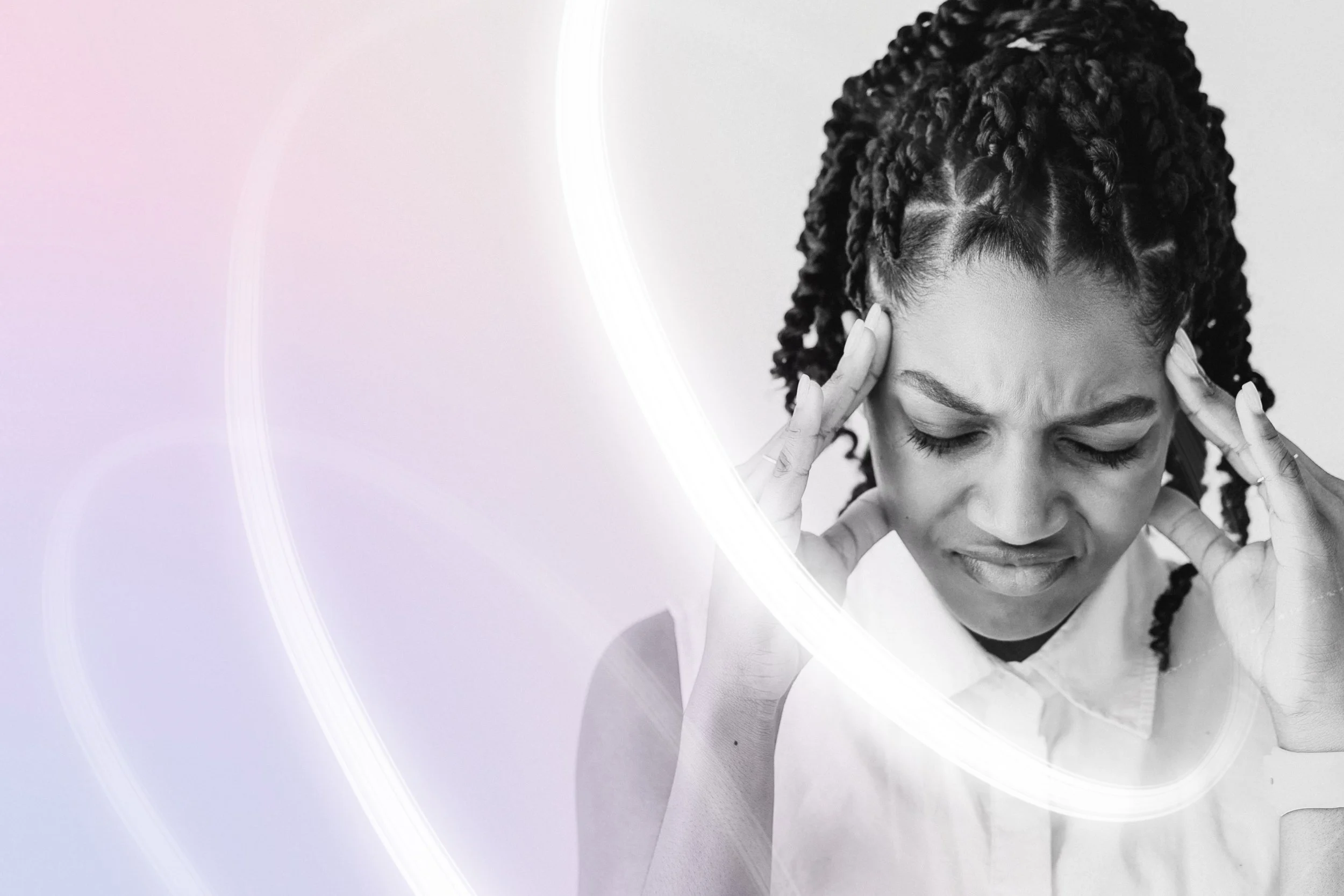 A black-and-white photo of a woman with braided hair holding her head and appearing stressed or in pain, with a light-colored background and a glowing white arc in the foreground.
