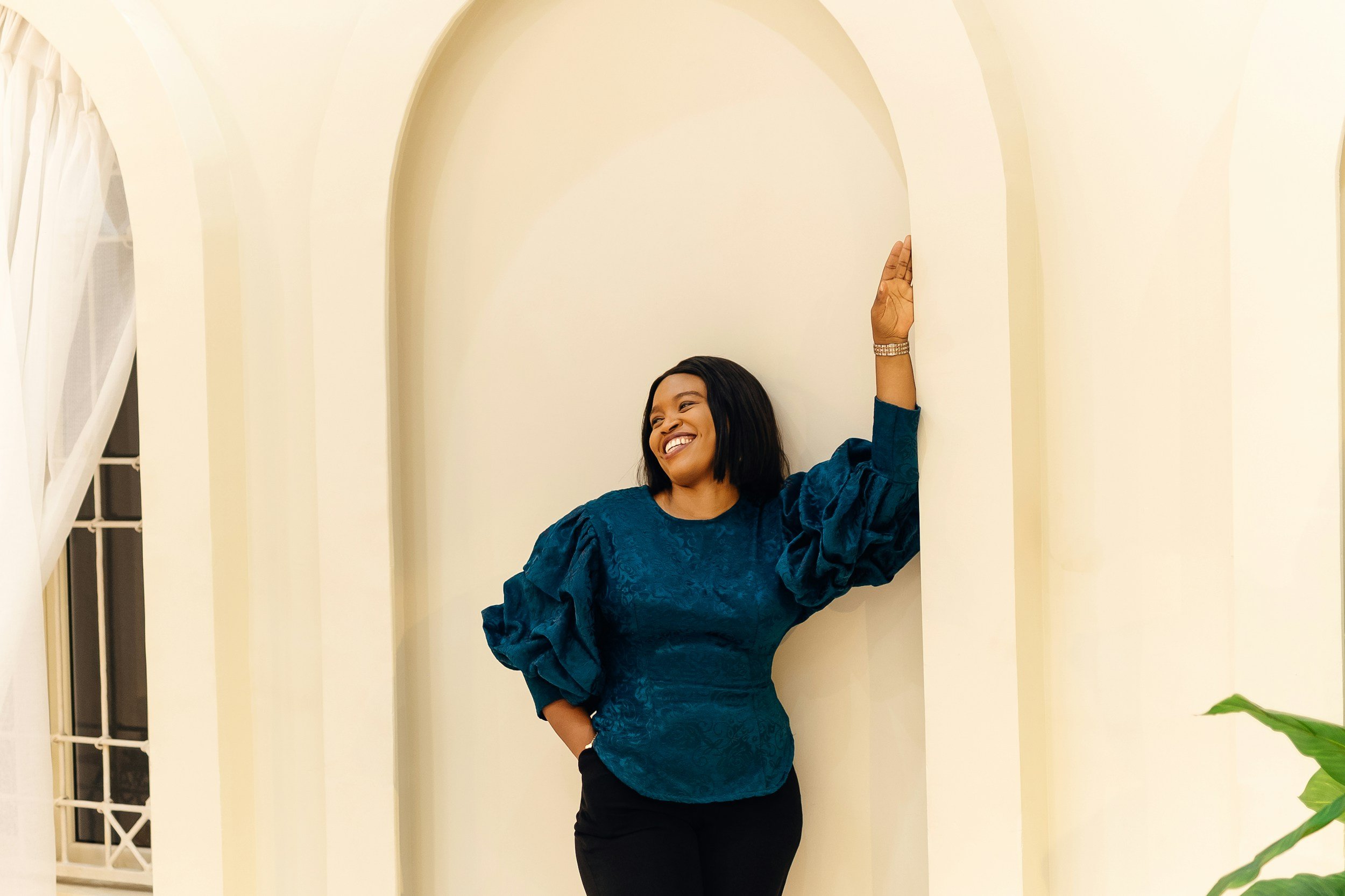 Confident woman smiling while standing tall symbolizing empowerment, emotional healing, confidence, and personal growth.