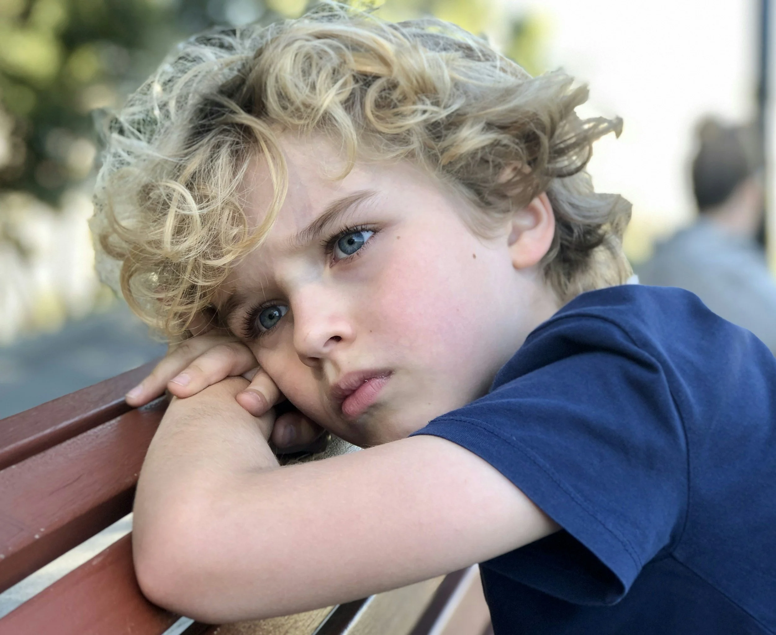 Young child looking sad and withdrawn, highlighting symptoms of childhood depression, emotional distress, and adolescent mental health concerns.