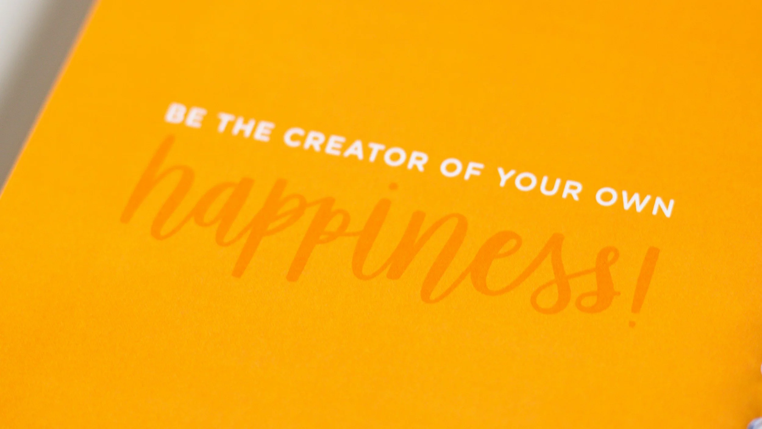 Yellow background with the phrase "Be the Creator of Your Own Happiness" representing emotional wellness, positivity, and choosing happiness intentionally.