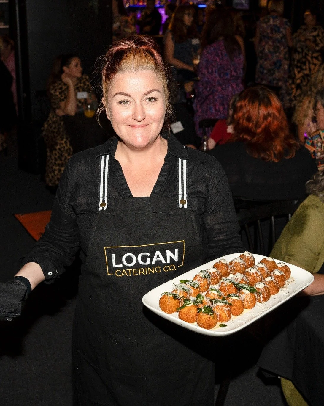 Logan Catering Co chef Rebecca Cobbing serving arancini canapés at catering event
