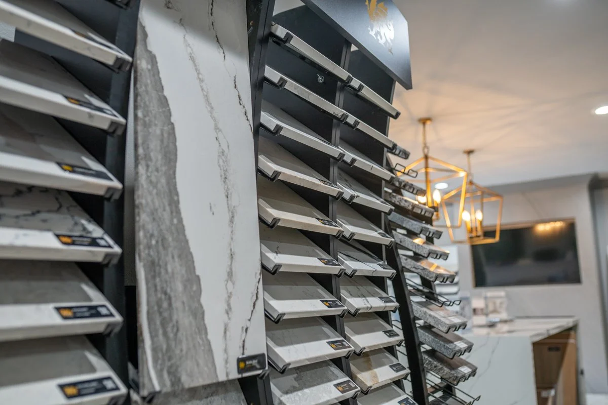 Display of various slabs of marble and stone tile samples in a showroom.