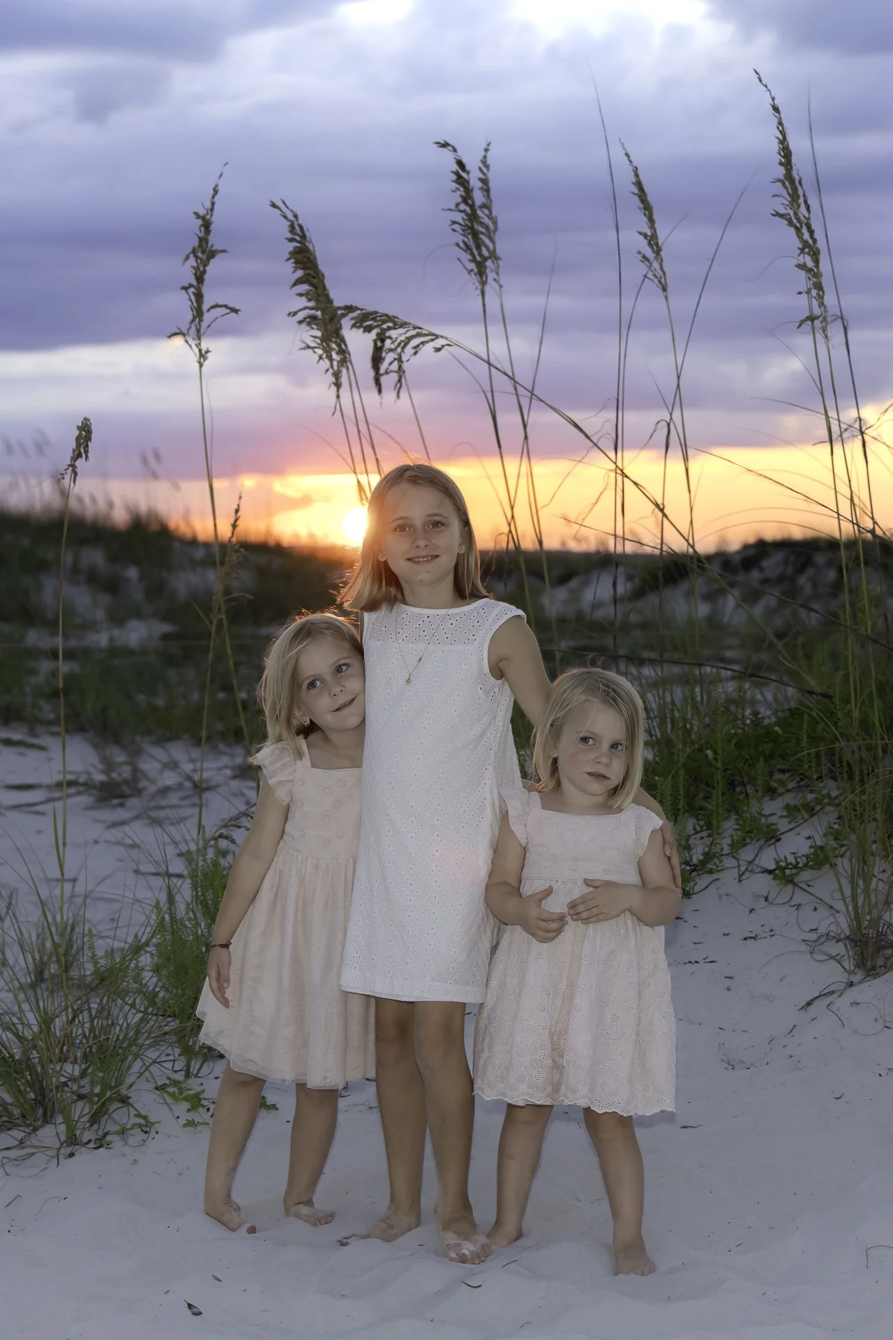 sisters posing for a sunset portrait on Pensacola Beach