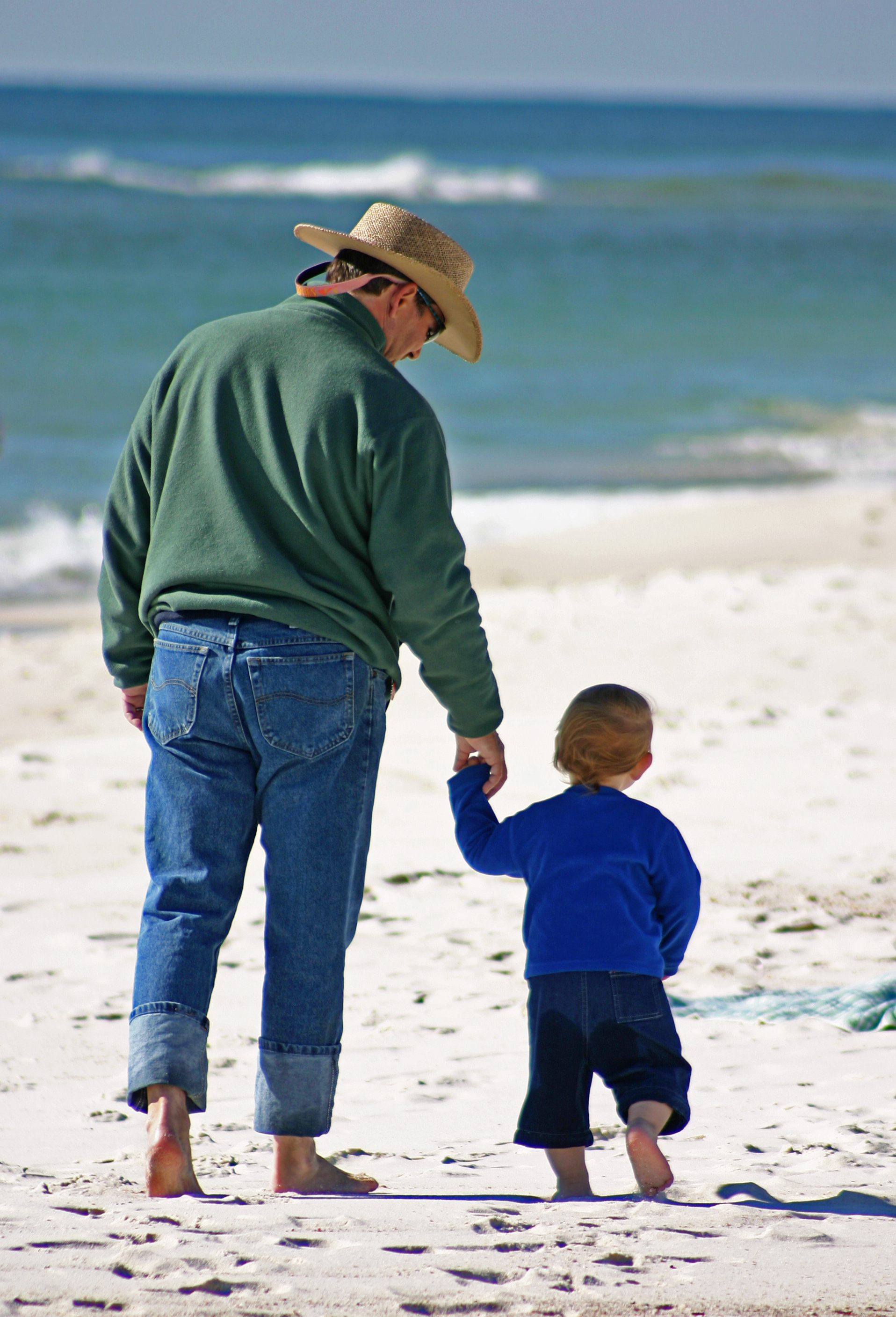 Daddny & toddler walking along the shoreline, Perdido Key, FL