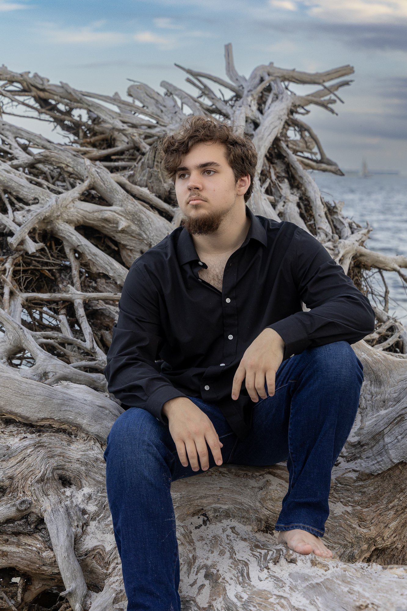 Moody Sr rests on driftwood on the shore of the Bay in Gulf Breeze FL
