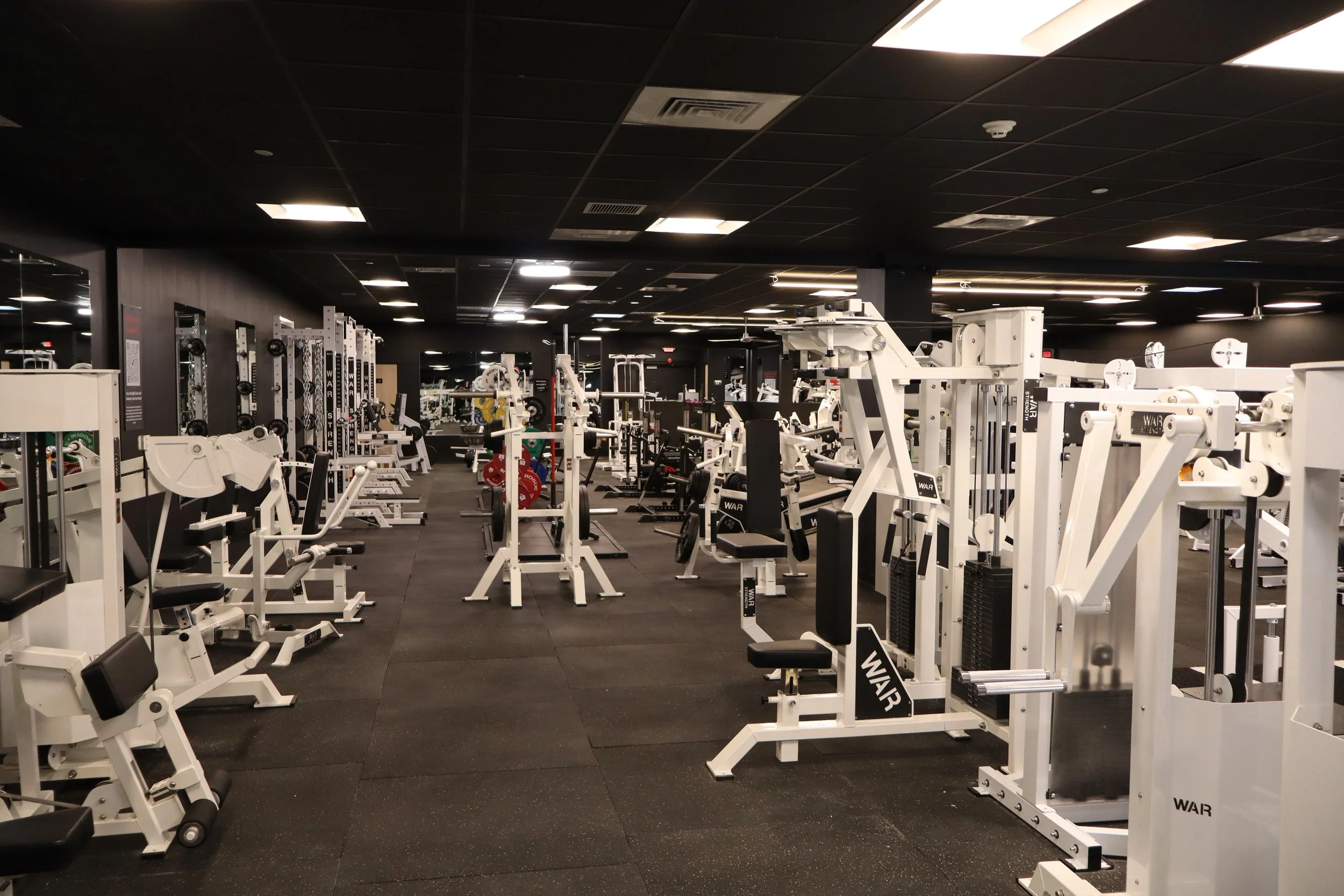 Empty gym with various workout equipment and machines.