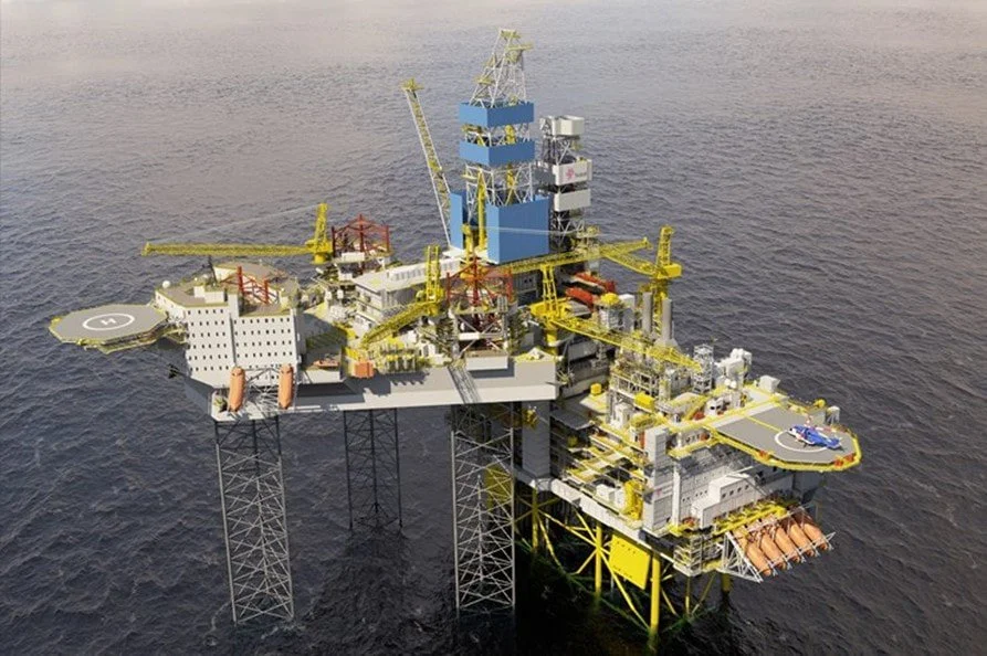 Offshore oil drilling rig in the ocean with cranes and helipad.