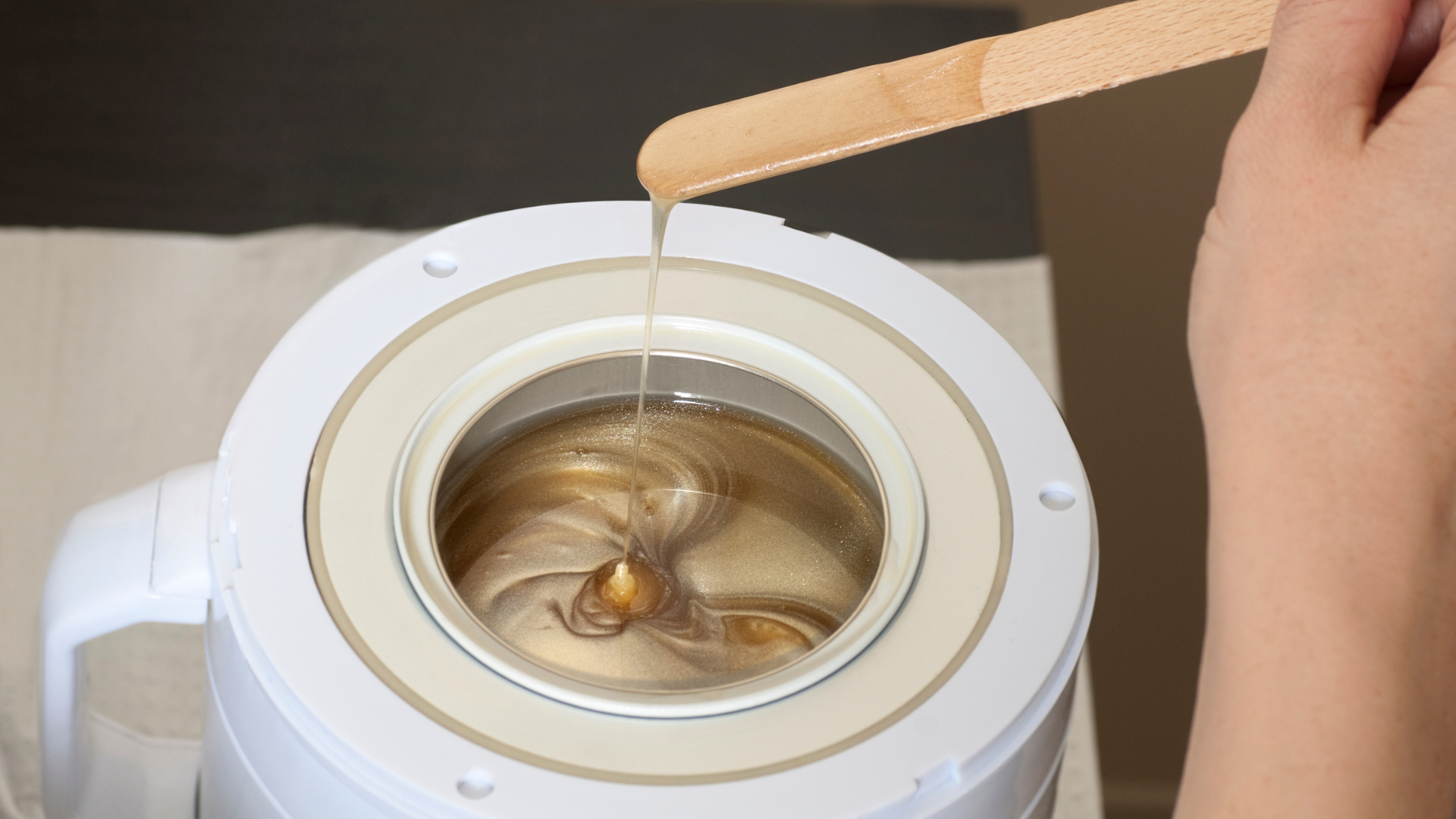 Person pouring liquid chocolate into an ice cream maker.