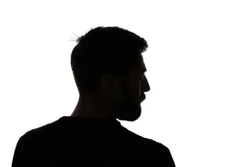 Silhouette of a man with a beard looking to the side against a white background.