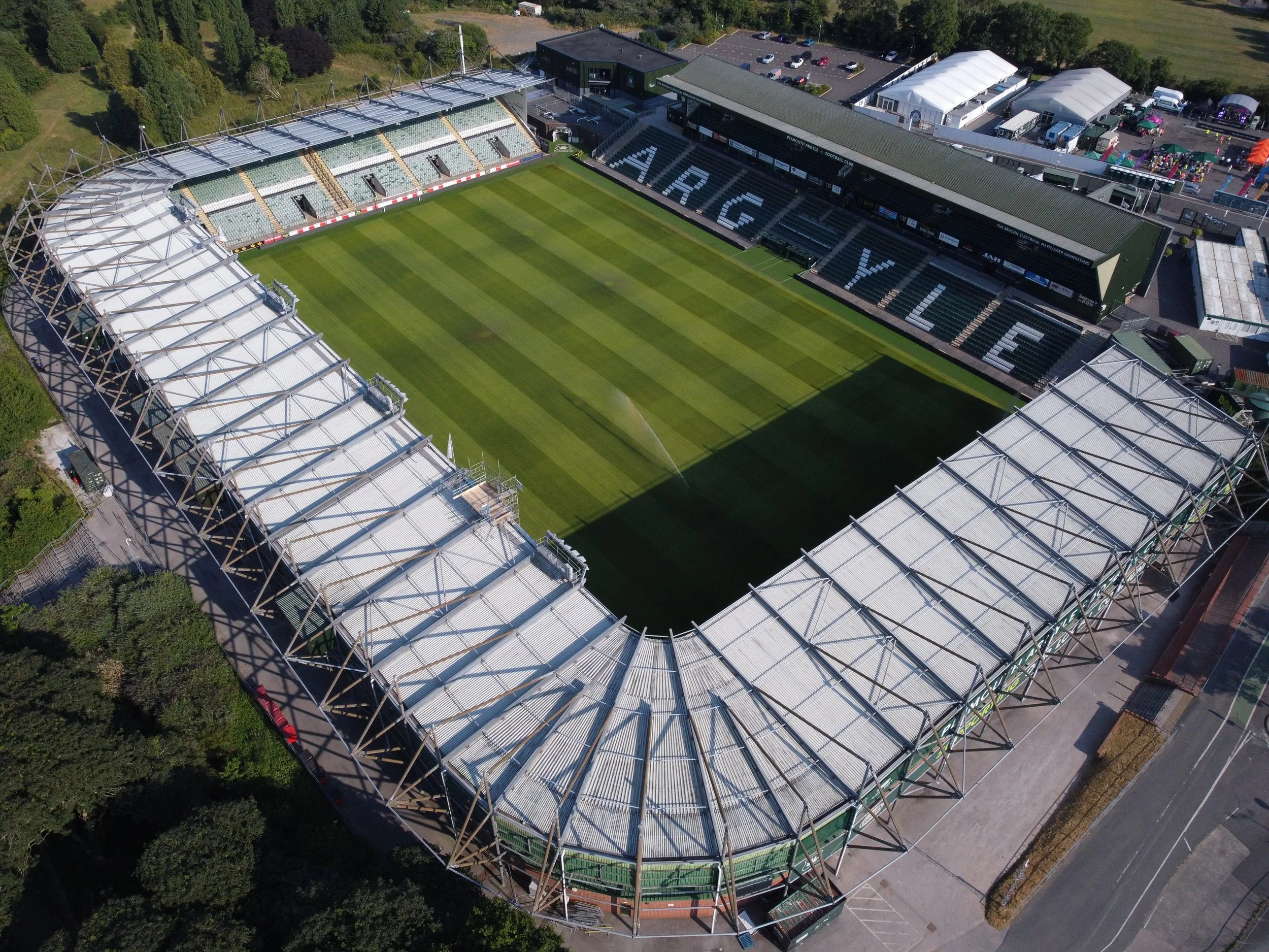 Aerial view of a soccer stadium with a lush green field and seating areas reading 'ARGY' and 'F