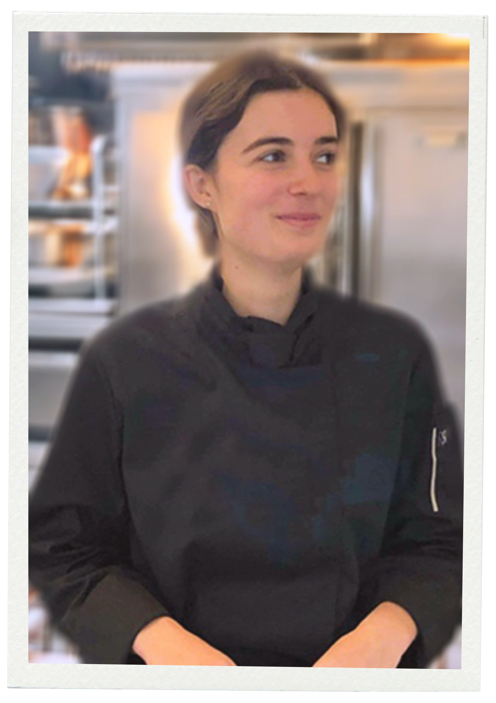 Bertille en uniforme de chef cuisinier dans une cuisine.