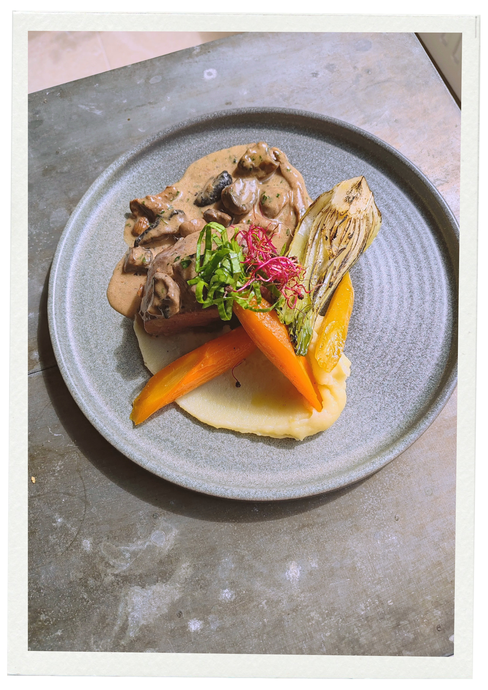 Plat de viande avec sauce aux champignons, légumes grillés, purée de pommes de terre, et garniture de légumes verts servi par dual food traiteur.