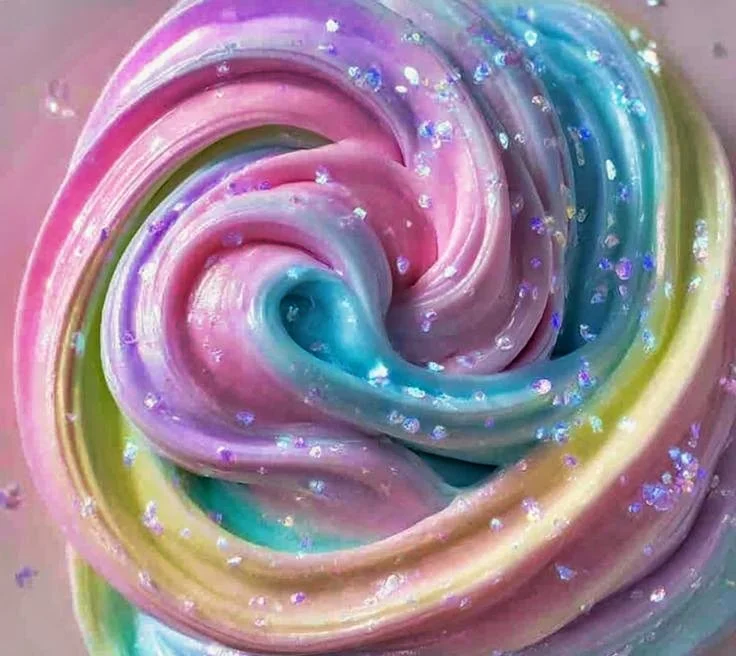 Close-up of pastel rainbow-colored swirl 67 Slime  with glitter particles.