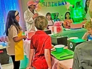 Children gathered around the host of 67 SLIME Co., as she is giving directions on creating and customizing their slime creations.