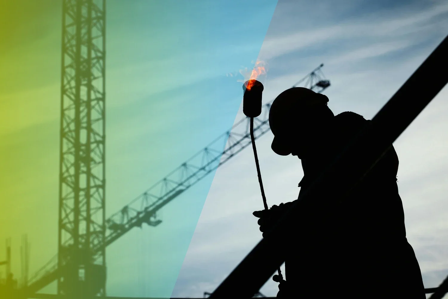 Two workers in high-visibility jackets working on underground utility installation, one holding a blowtorch and the other steadying a large red pipe in a trench.