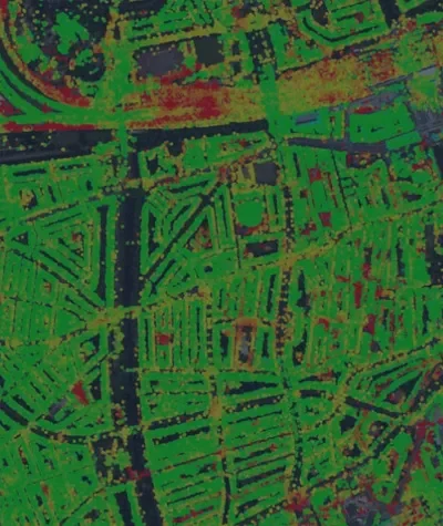 Colour-coded aerial map of an urban area, showing InSAR-derived deformation hotspots and stable zones across streets, buildings and green space.