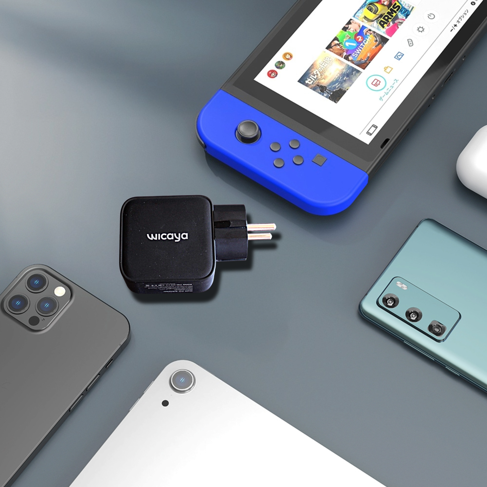 Collection de quatre téléphones portables de différentes couleurs, un chargeur Wicaya, et un AirPod sur une surface grise.