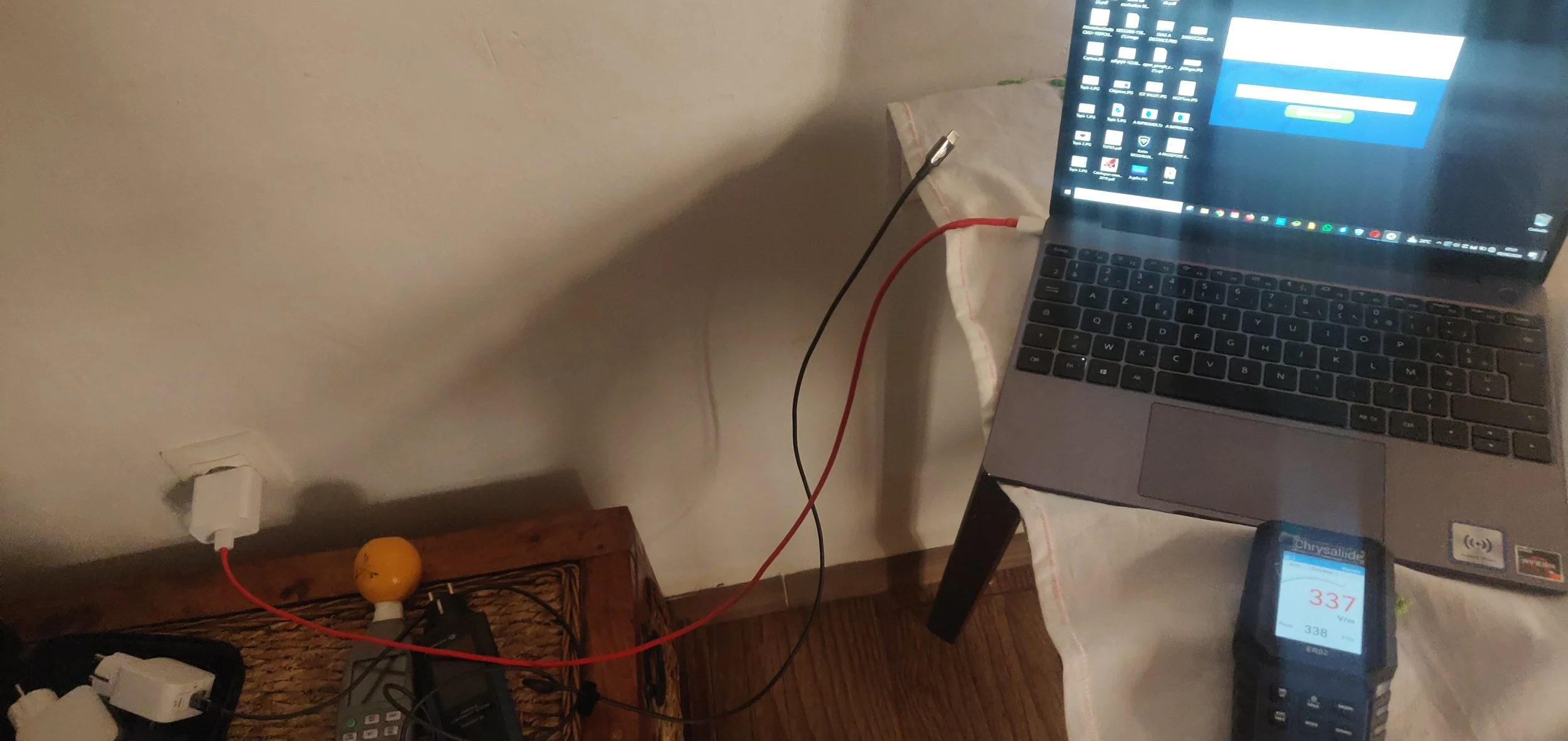 Un ordinateur portable en charge avec un chargeur sans terre et avec terre de wicaya. Pour comparer les niveau de champs électrique en volts par métre.