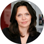 Une femme aux cheveux bruns, portant un maquillage léger, dans un intérieur domestique.