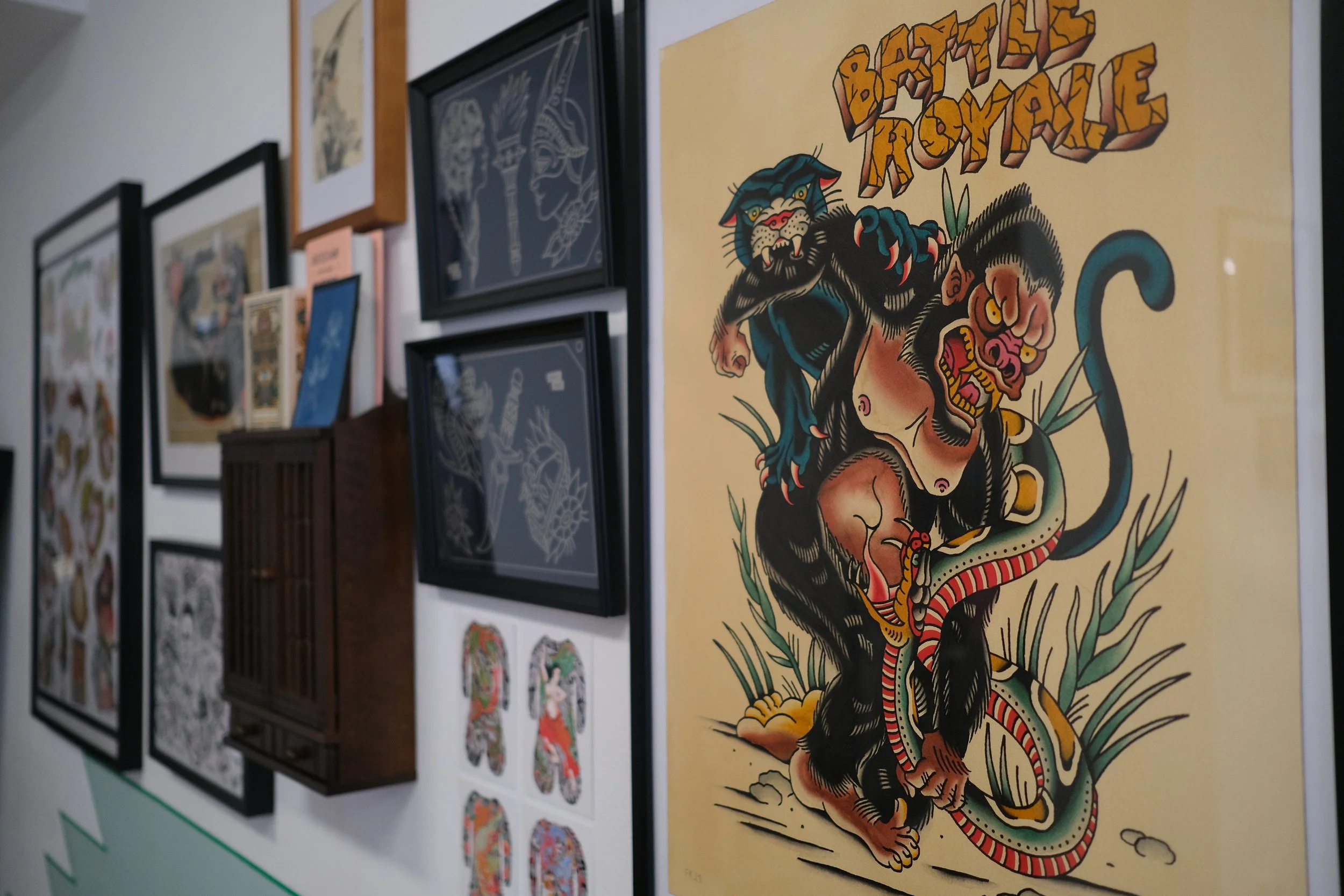 Ein Wandbild mit einem traditionellen Tattoo-Motiv, das einen Gorilla, Panther und eine Schlange zeigt, sowie den Text "Battle Royale" in der Oberseite.