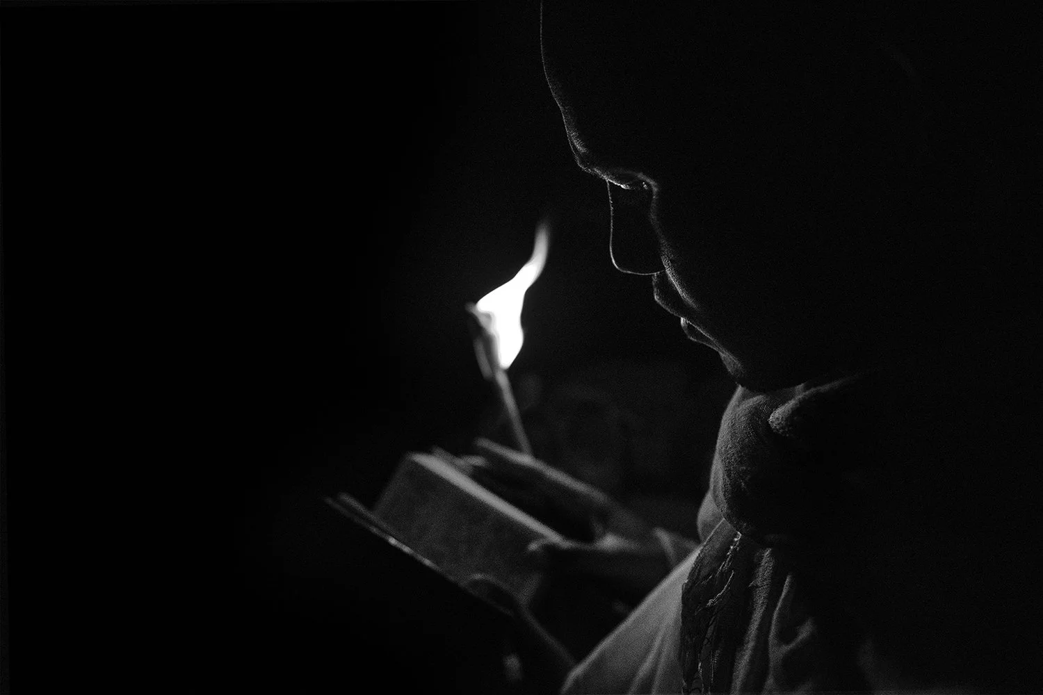 Hombre leyendo un libro a la luz de la pantalla