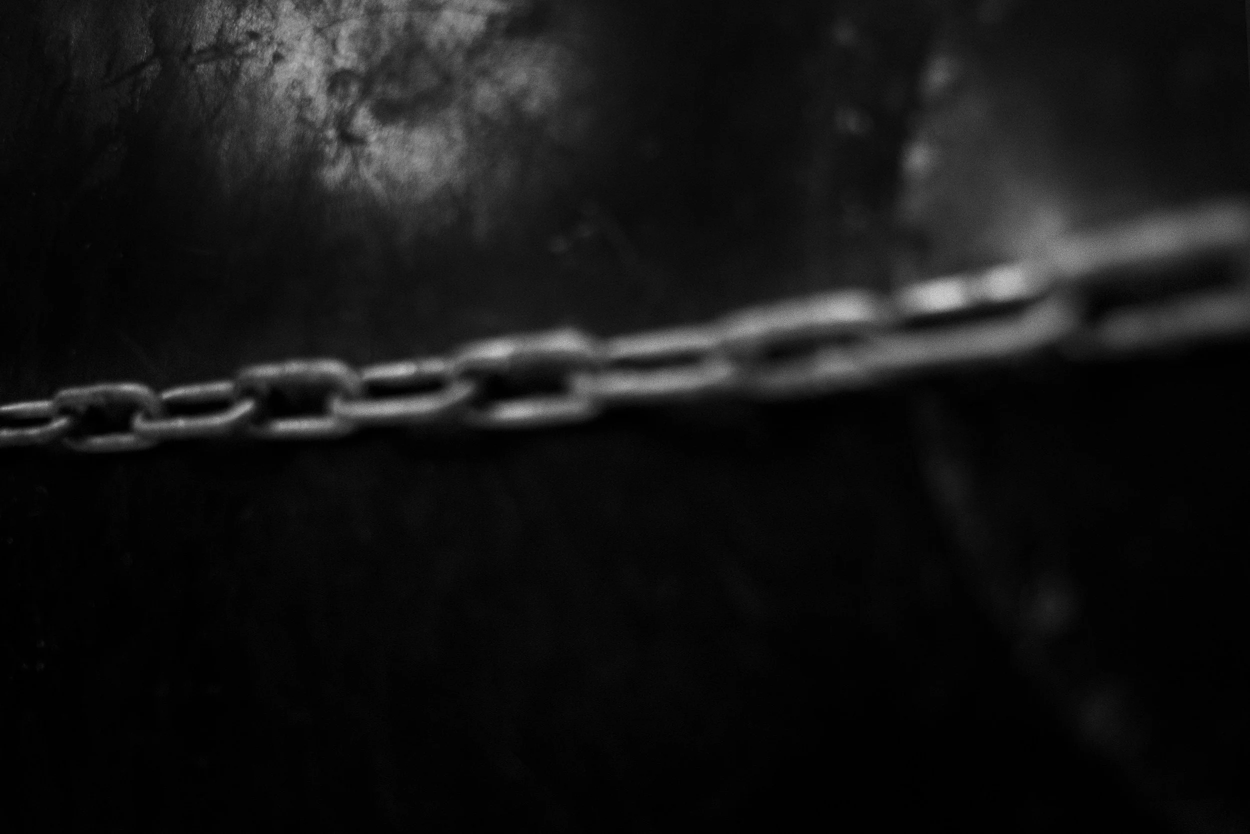 Cadena metálica en primer plano, fondo oscuro y difuso