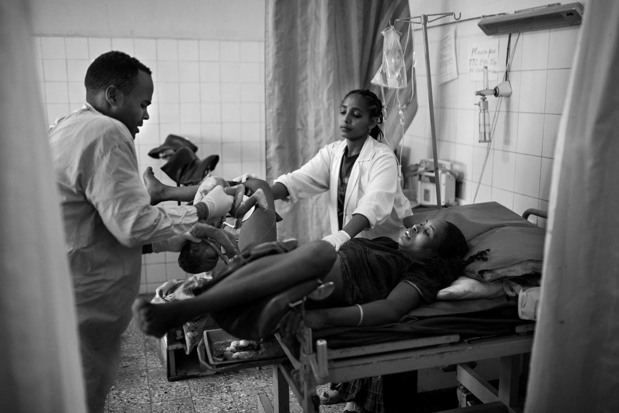 Médicos atendiendo a una mujer embarazada en un hospital, en un entorno clínico.