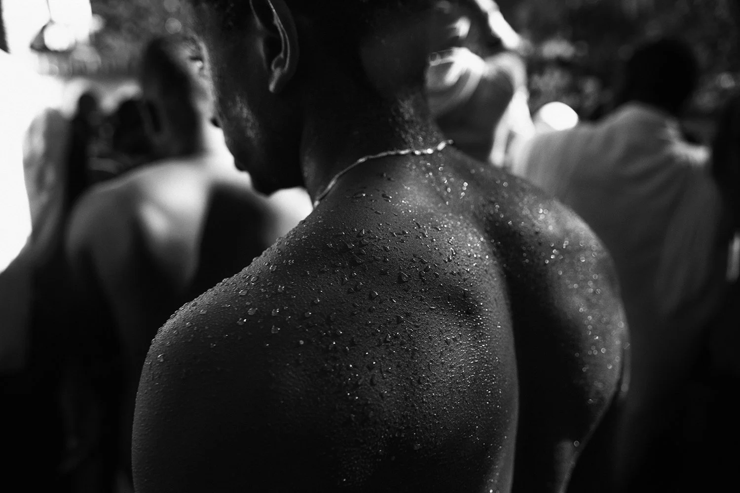 Hombro y cuello de una persona sudorosa en un entorno oscuro, en blanco y negro.