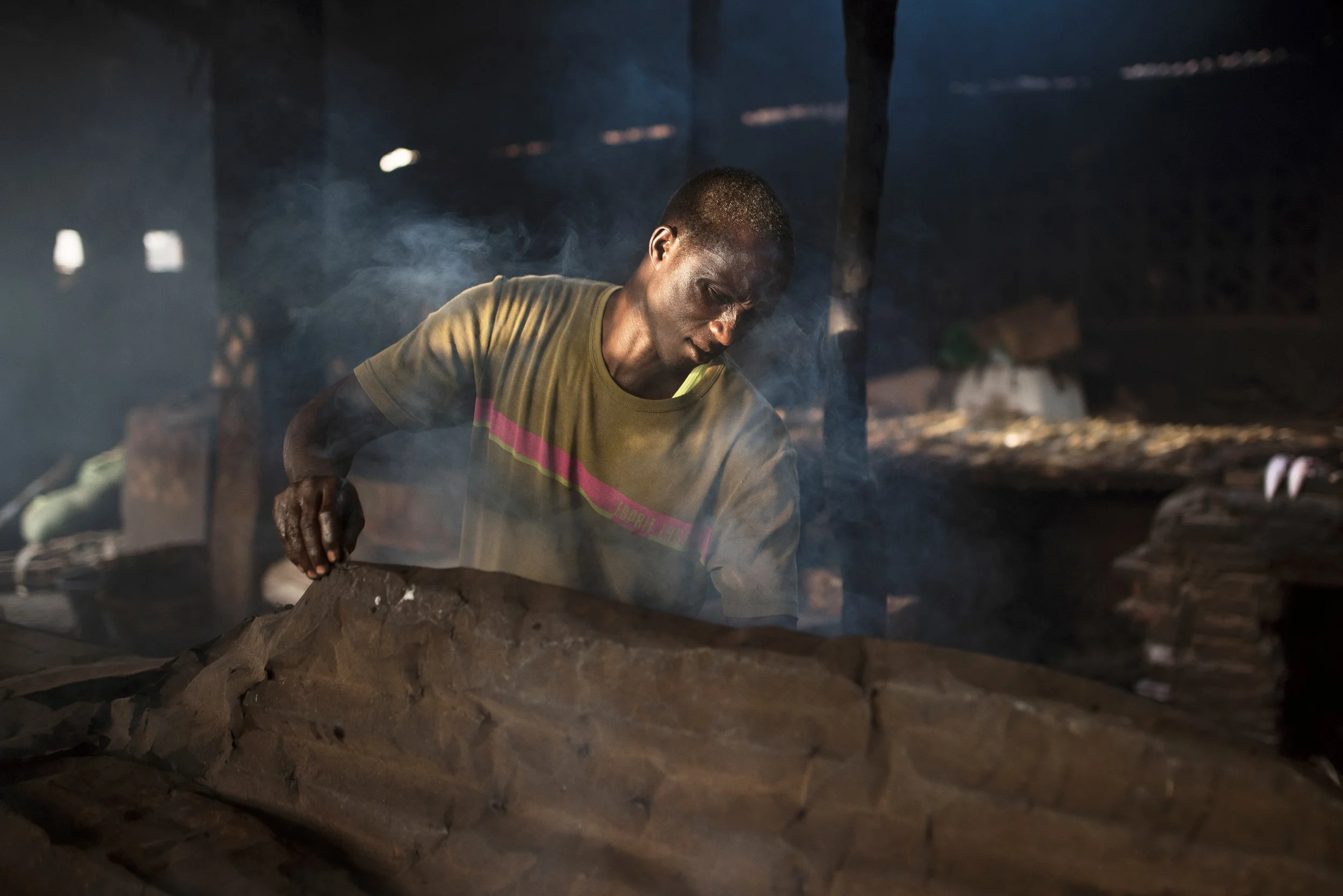 Hombre cocinando en una cocina tradicional con madera y humos