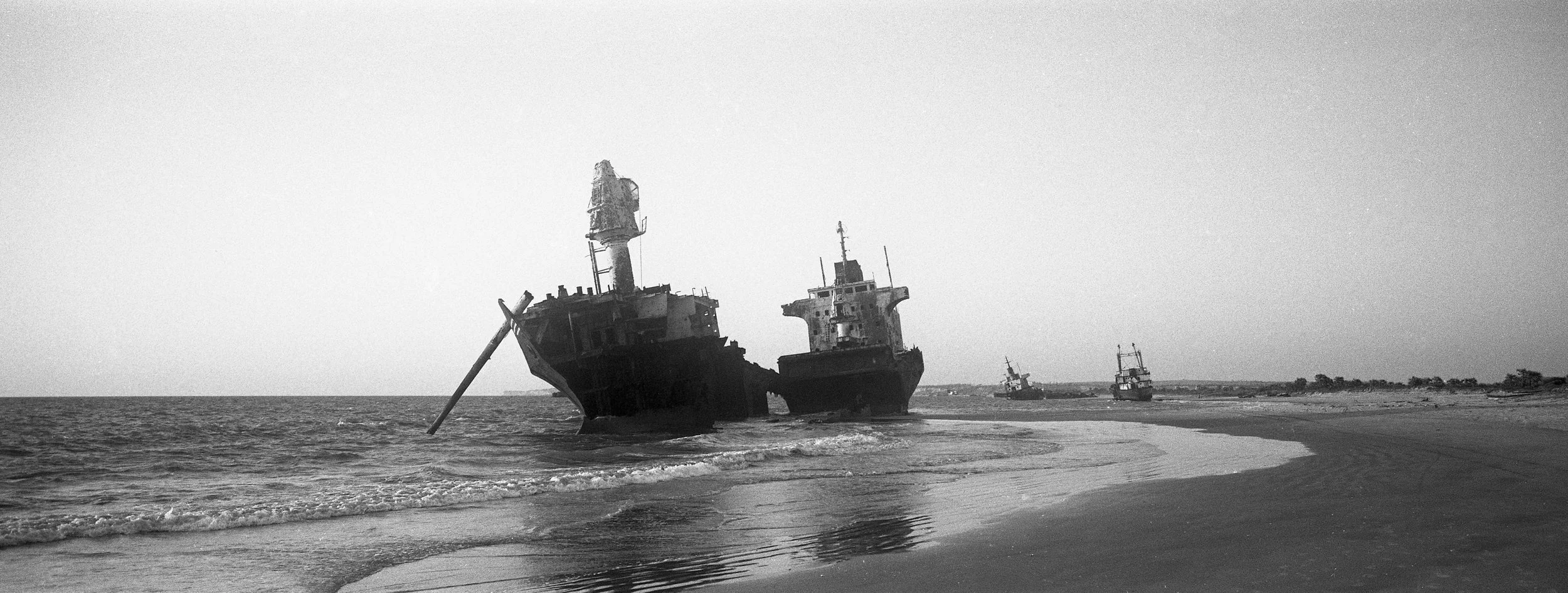 Barcos hundidos en la orilla en blanco y negro.