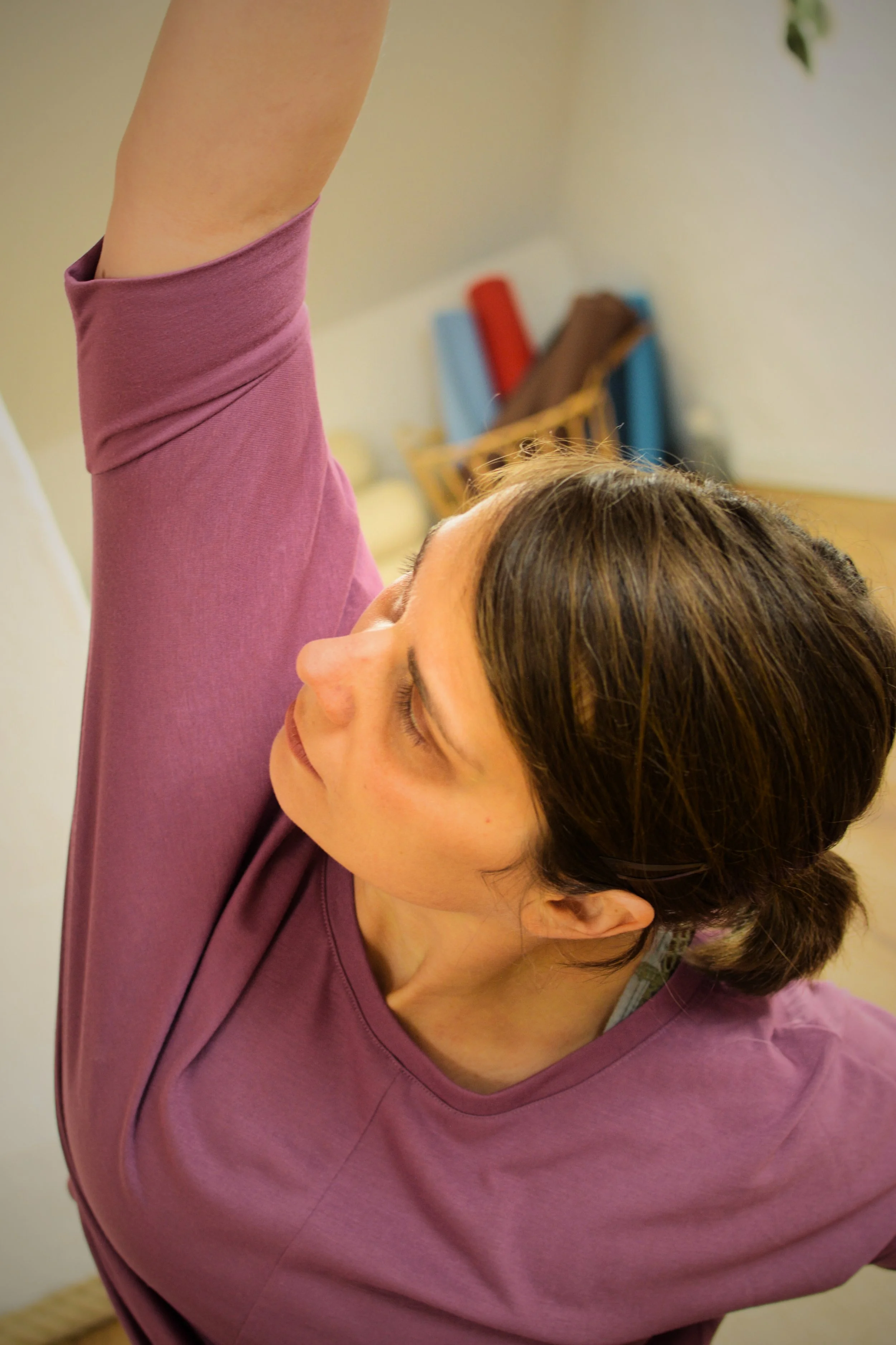 Pia Duve macht eine Yoga-Pose auf dem Dachboden. Der rechte Arm wird über den Kopf gestreckt.
