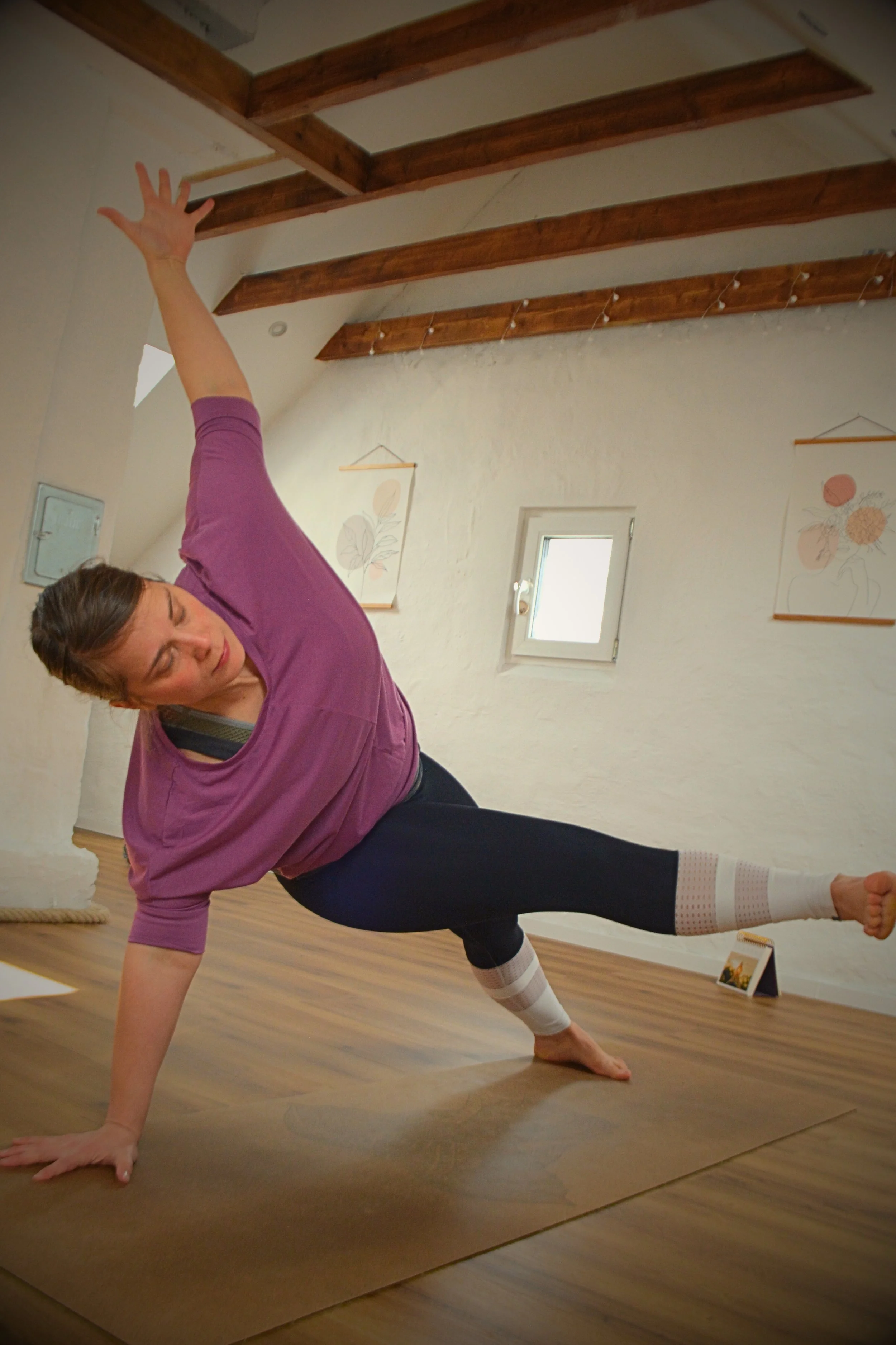 Pia Duve macht auf dem Yoga-Dachboden eine seitliche Planke mit angehobenem Bein.