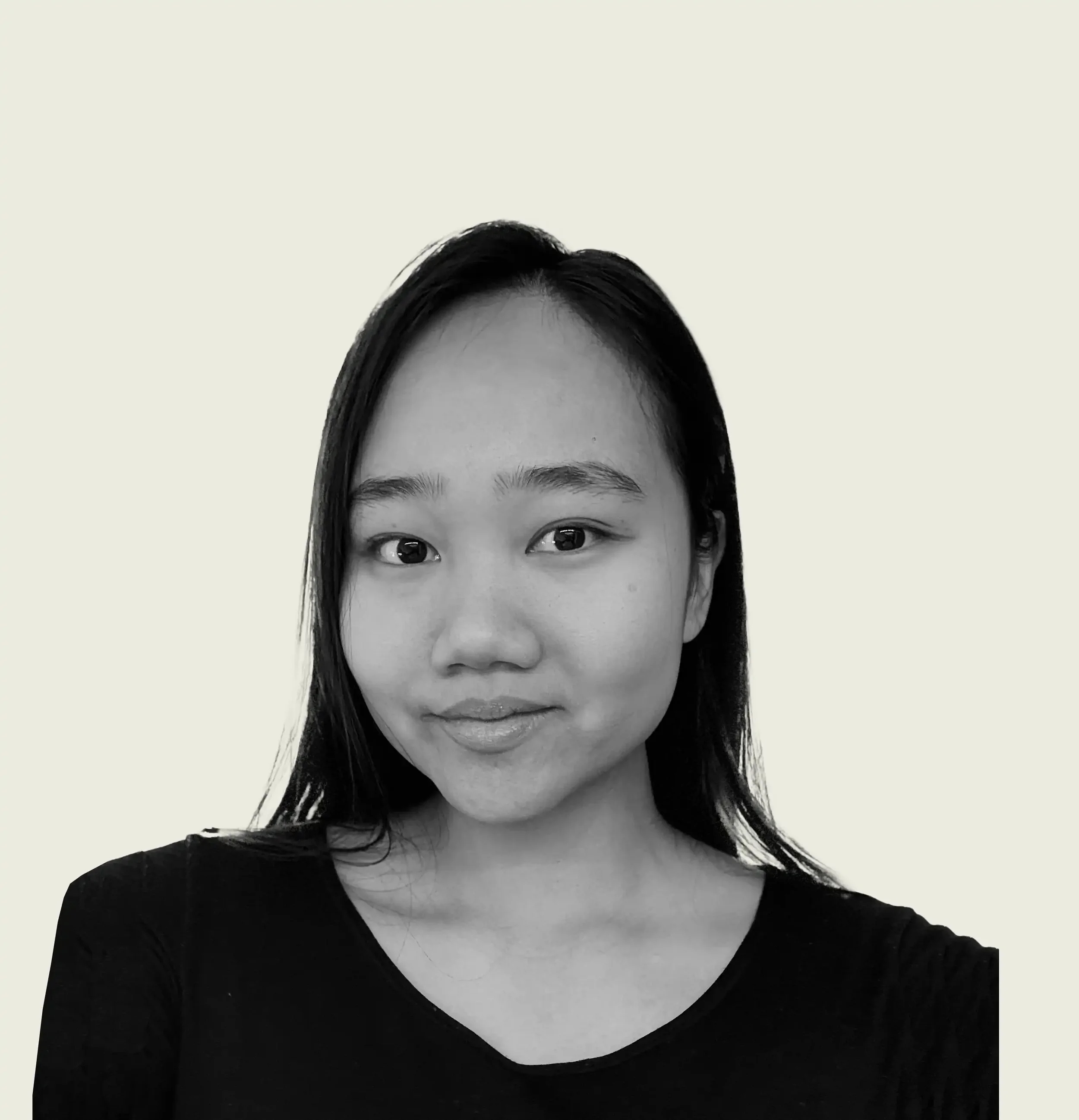 Portrait en noir et blanc d'une femme asiatique souriante avec des cheveux noirs et un t-shirt noir, fond clair.