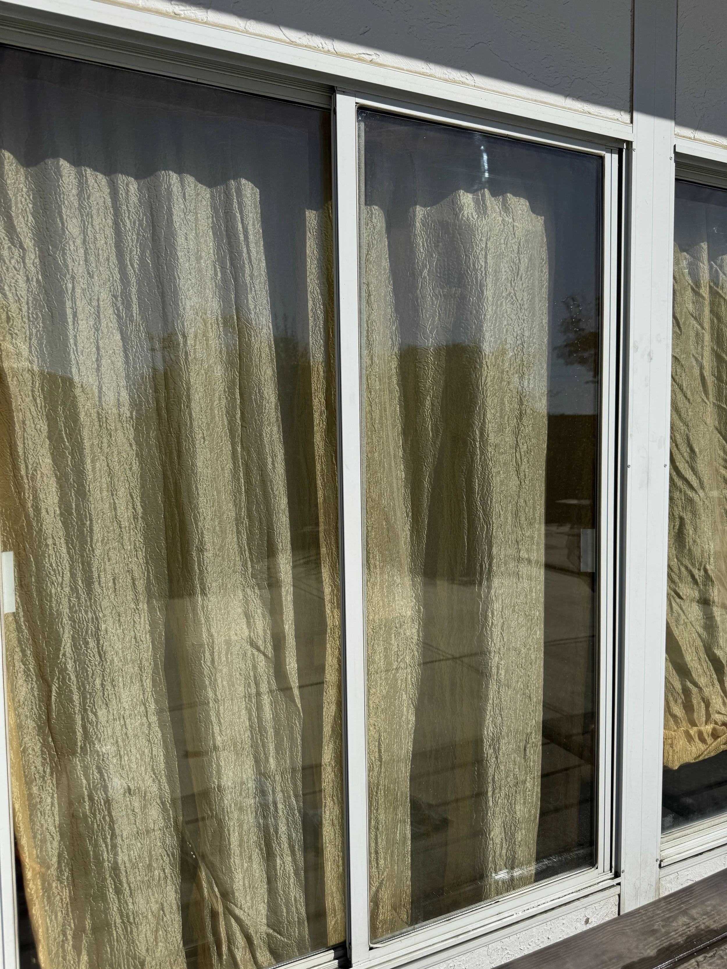 Spotless glass patio windows reflecting bright sunlight after professional washing.